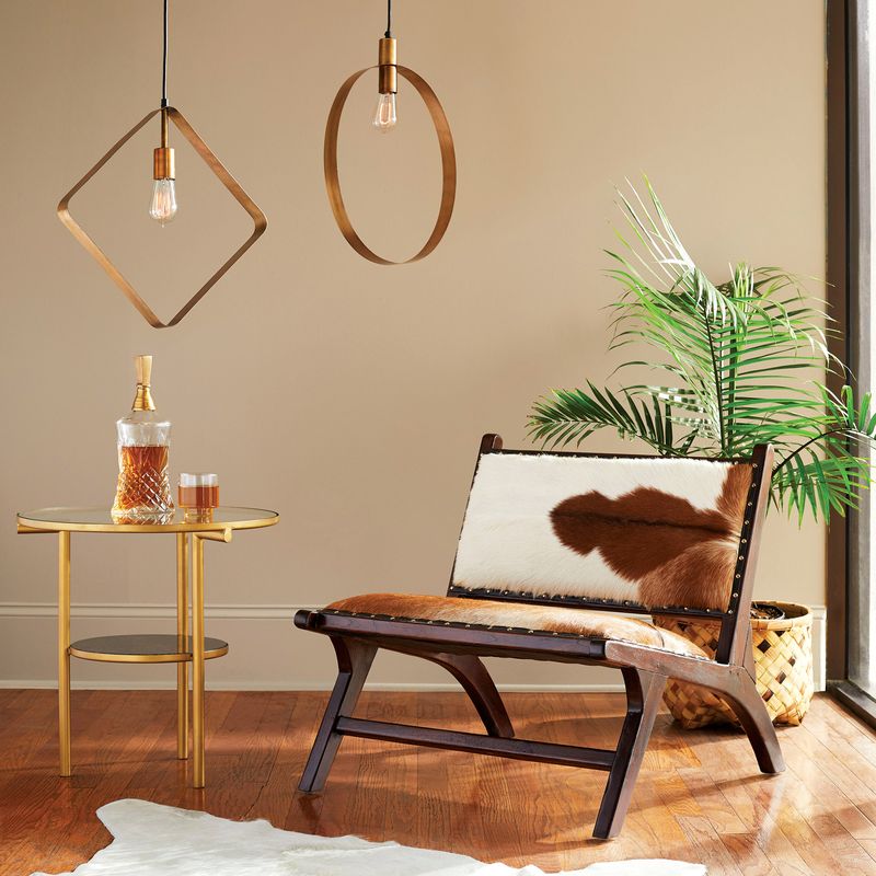 Outstanding Ariana Pendant hanging in living room in Antique Brass