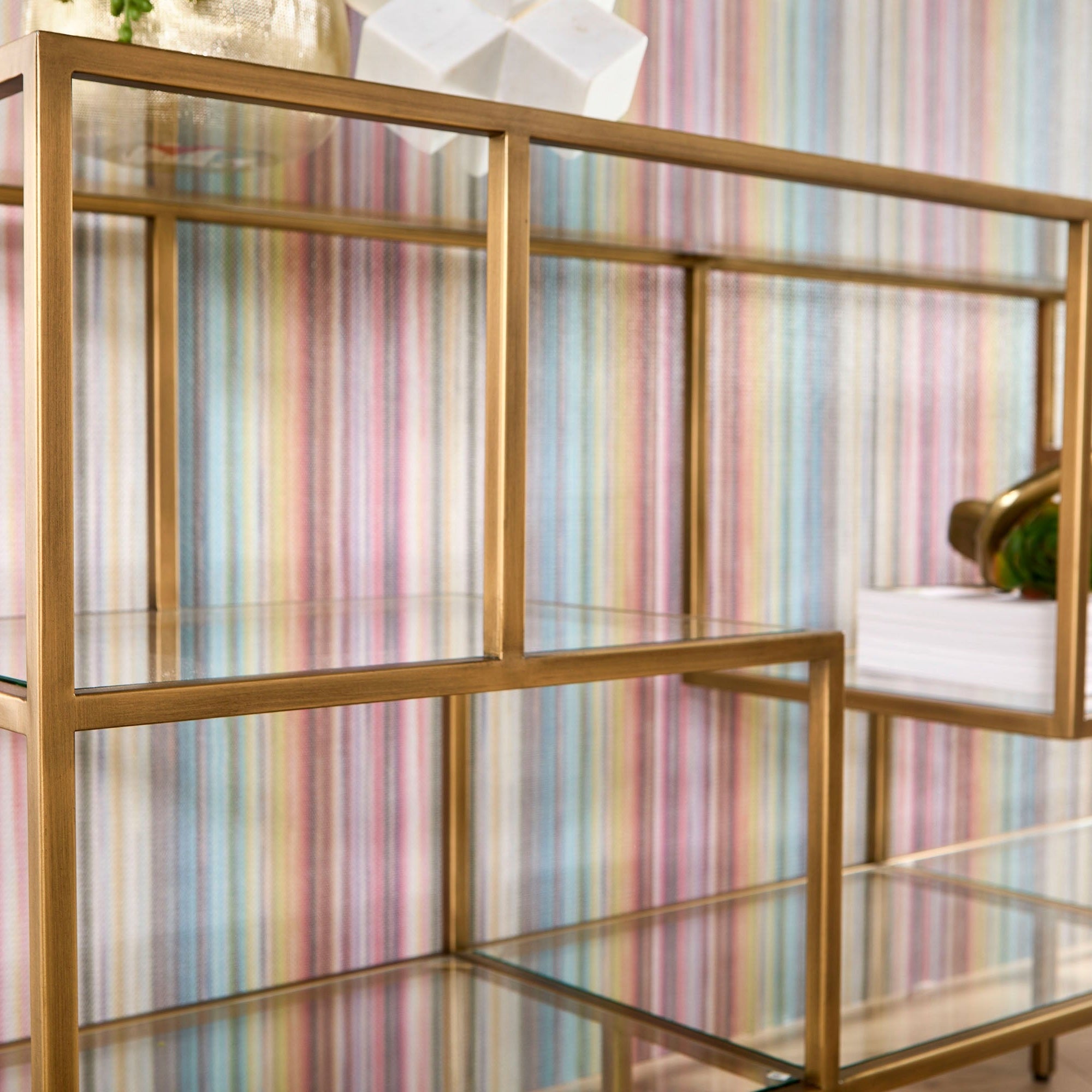 Beakman Low Bookcase with brass metal frame and clear glass shelves in modern design by Essentials For Living
