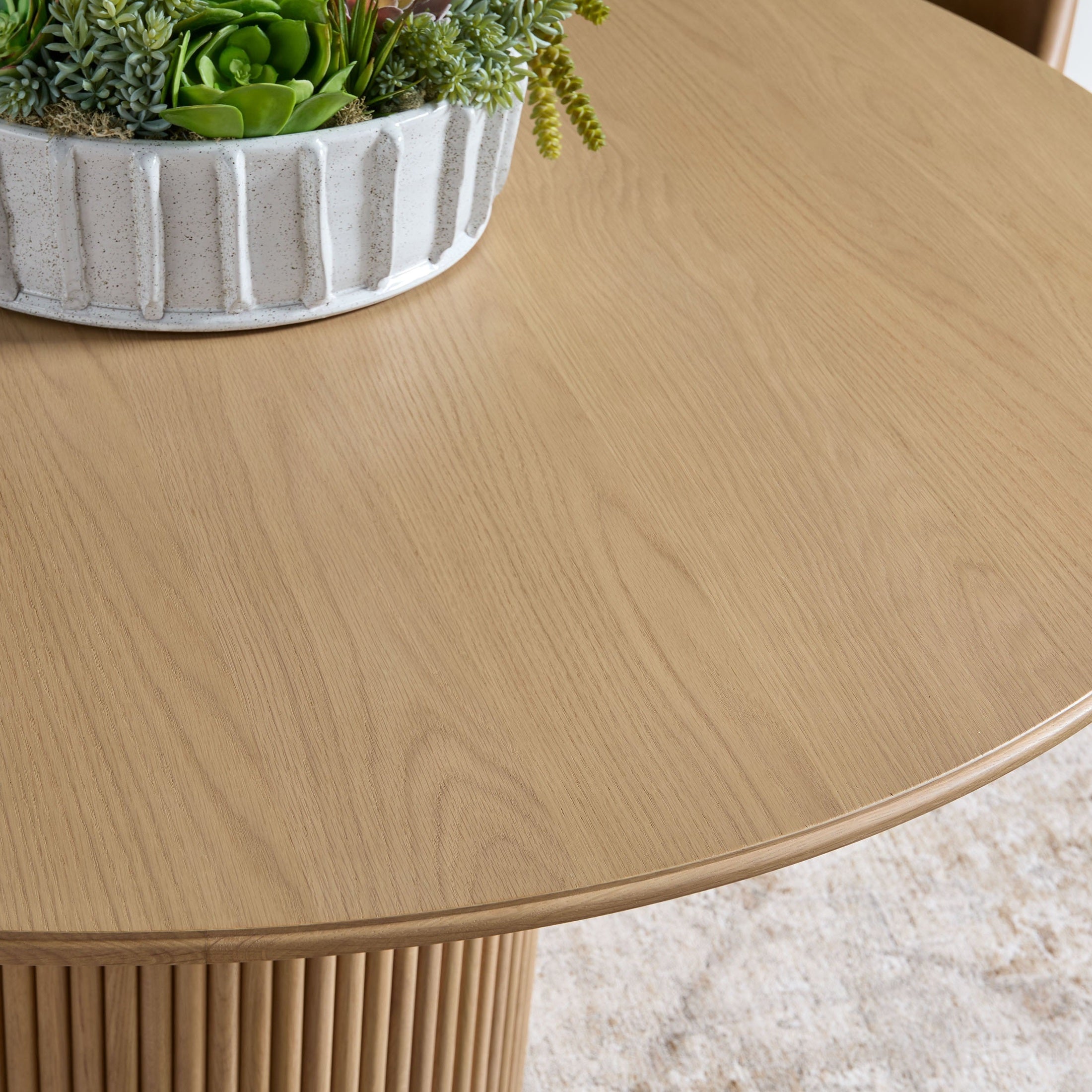 Close-up of Belfast 54" Round Dining Table natural oak top and fluted pedestal base by Essentials for Living.