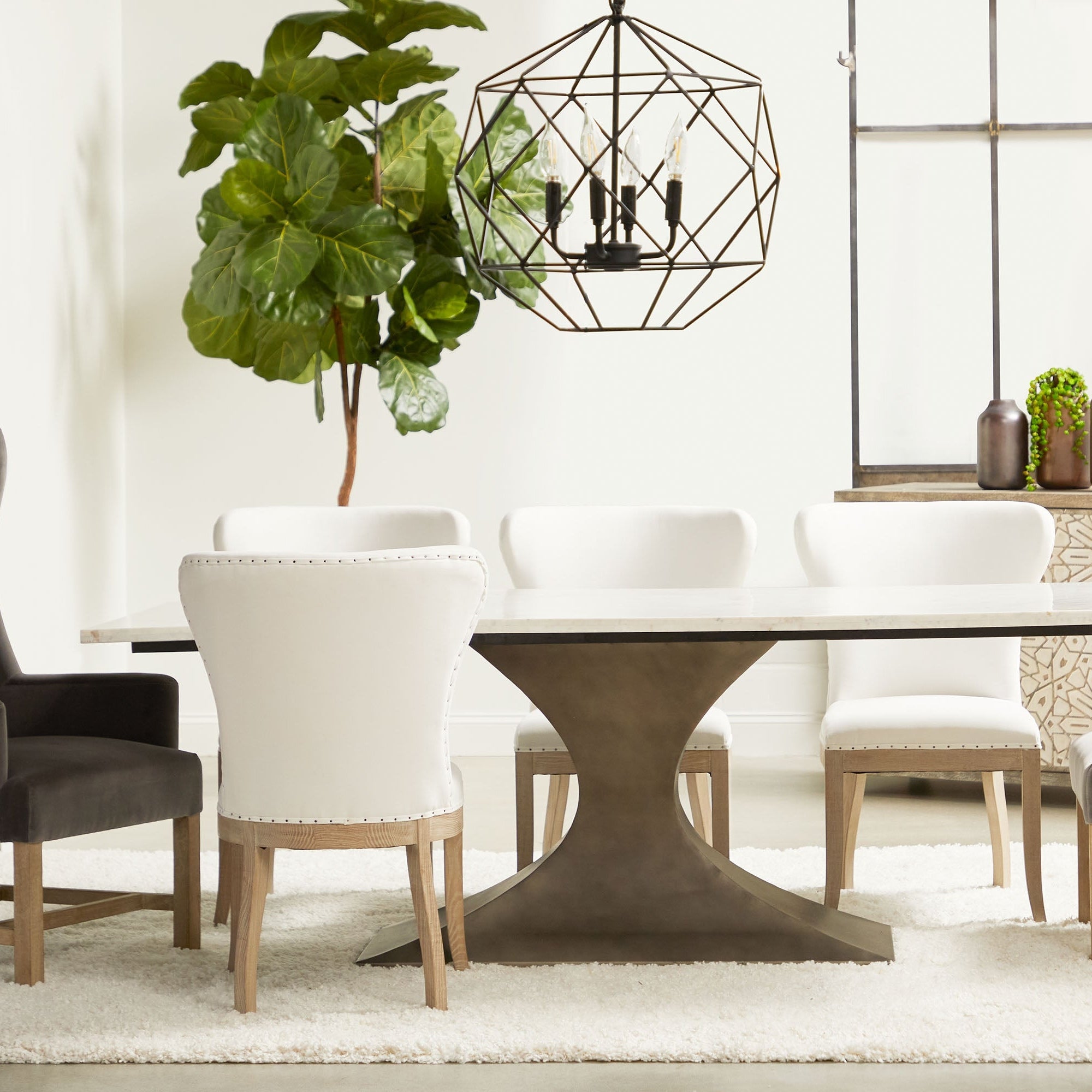 Dining room setup with white Bennett Arm Chair and dark wood table by Essentials For Living