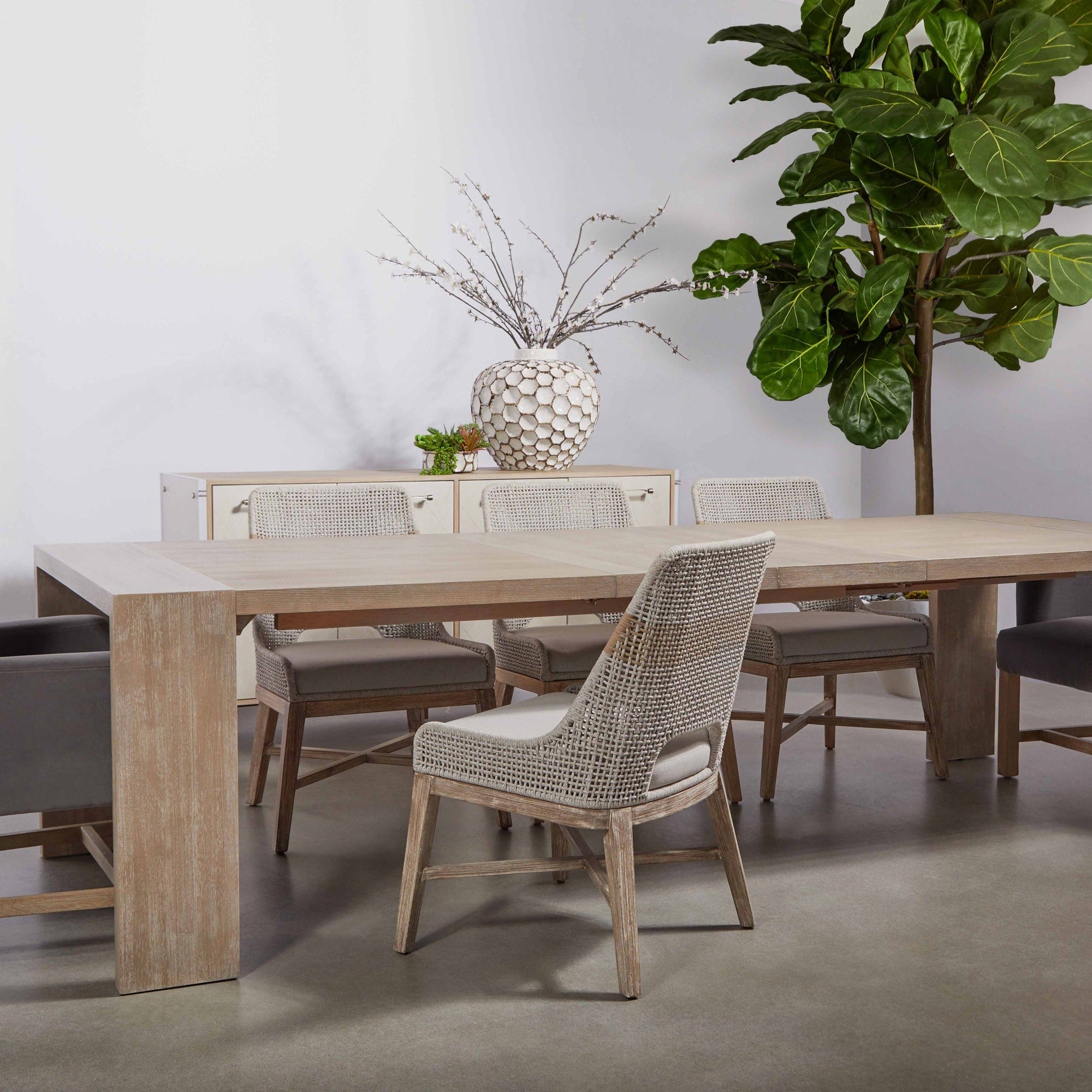 Dining room with woven back chairs and a large wood table in neutral tones, Essentials for Living Bennett Arm Chair.