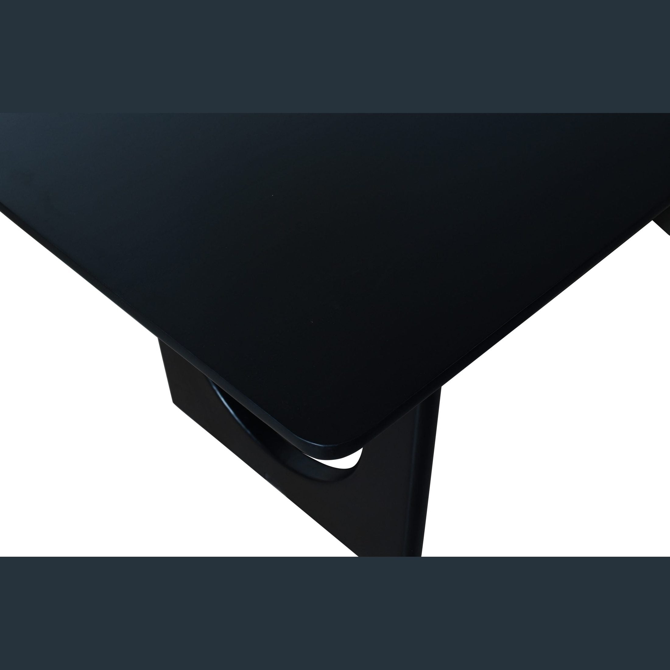 Close-up of the matte black solid wood surface and leg design of the Blanco Dining Table by GO HOME.