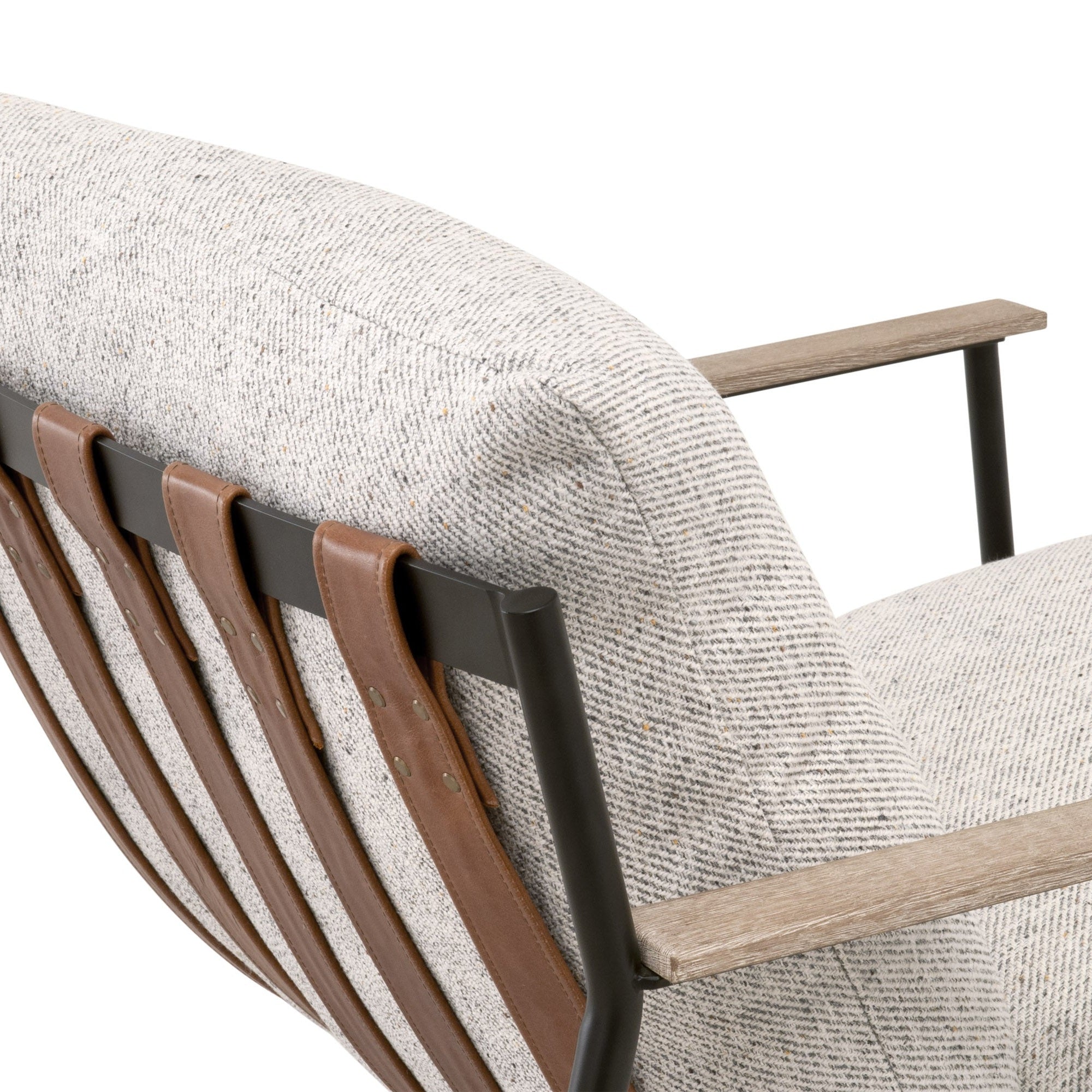 Close-up of Brando Club Chair with black iron frame, chestnut leather straps, gray oak armrests, and fabric cushion by Essentials for Living
