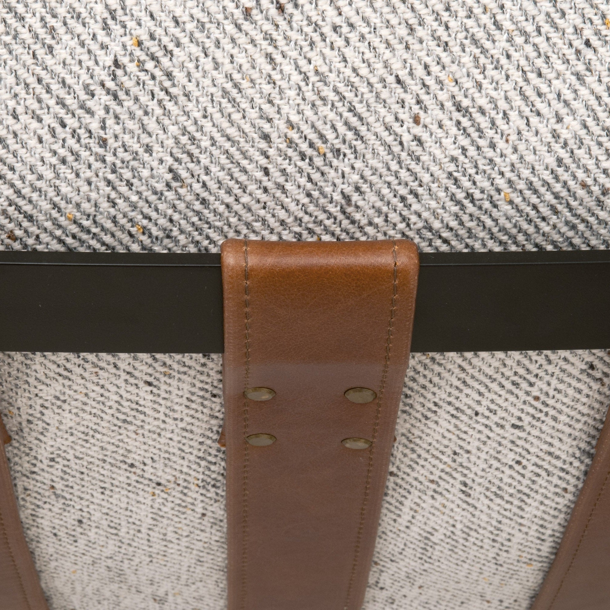 Close-up of chestnut brown leather strap and black iron frame on Brando Club Chair by Essentials for Living