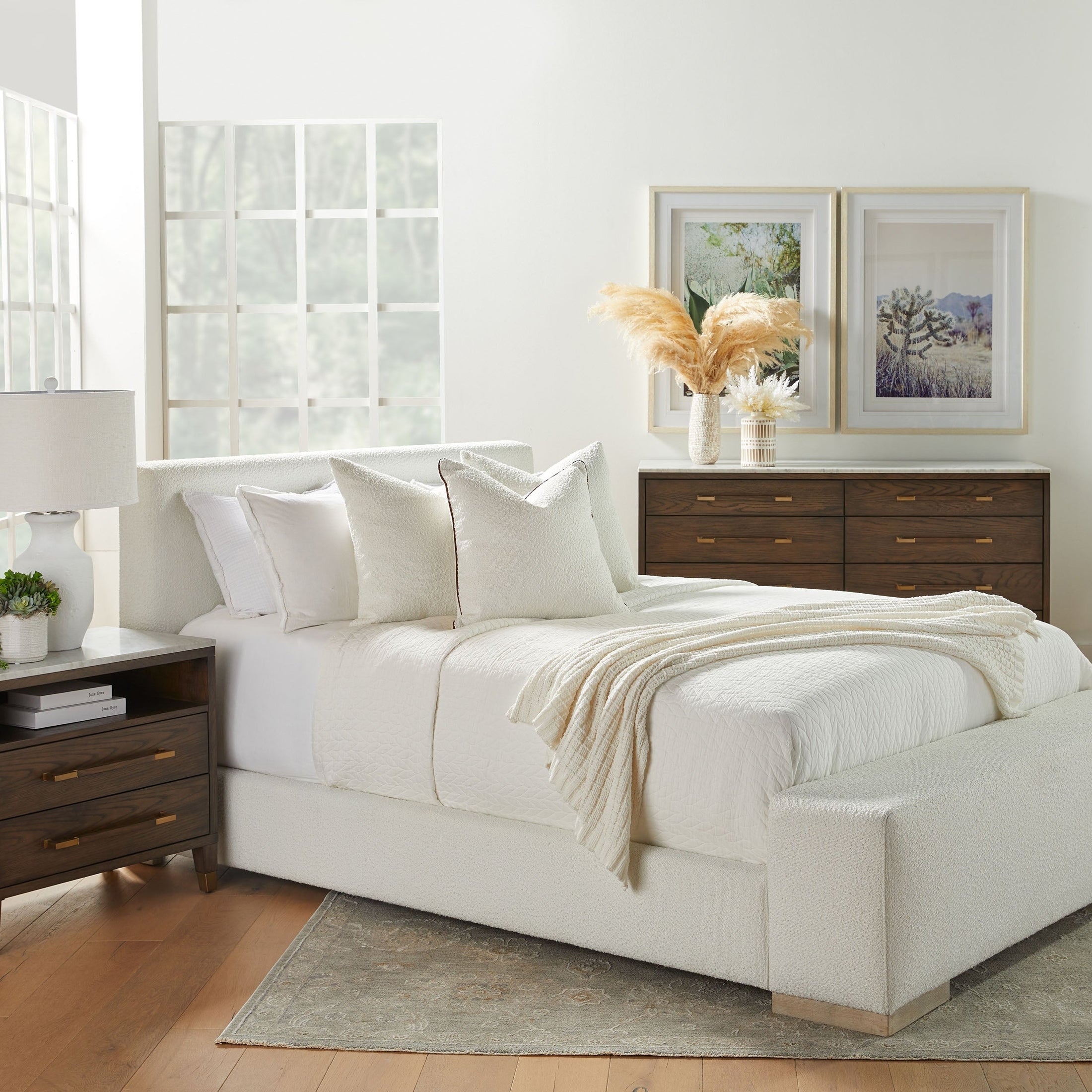 Modern white upholstered bed with textured blankets and wooden furniture in bright room Essentials for Living Brando Club Chair