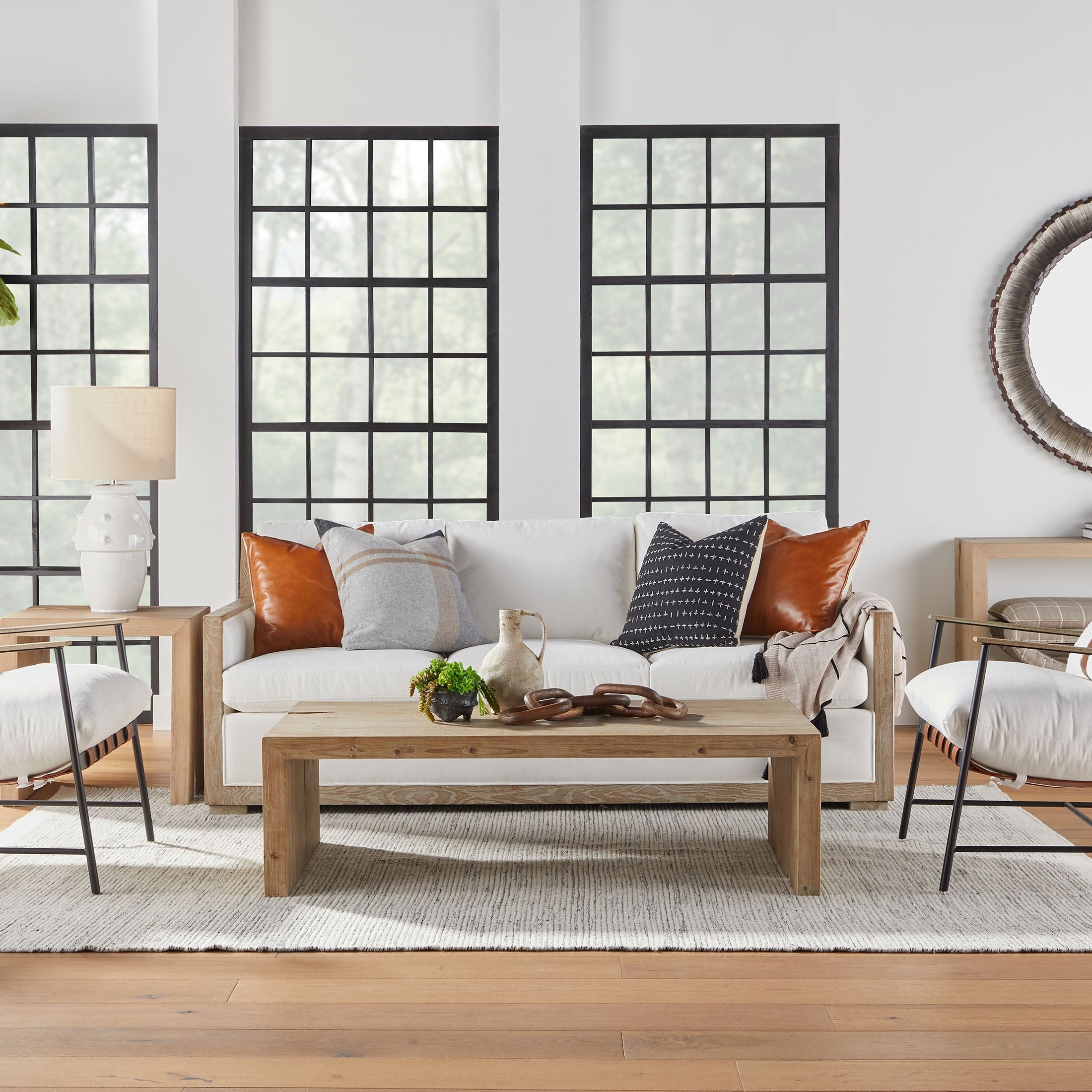Modern Brando Club Chair with black iron frame and chestnut leather straps in a stylish living room by Essentials for Living