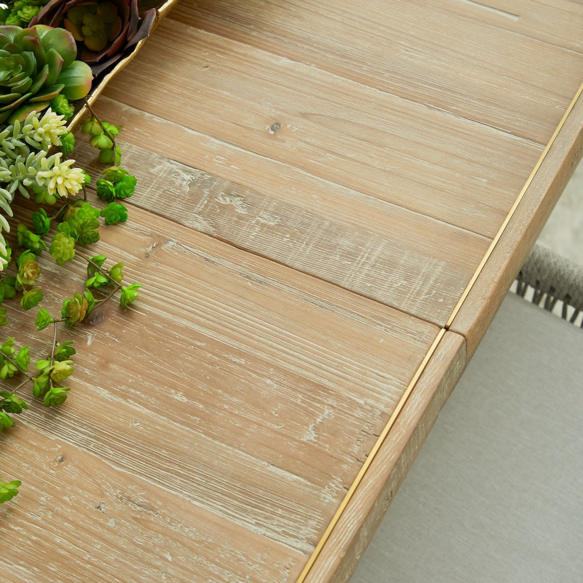 Close-up of Essentials For Living Canal Extension Dining Table top showing reclaimed pine wood and brushed gold inlay detail