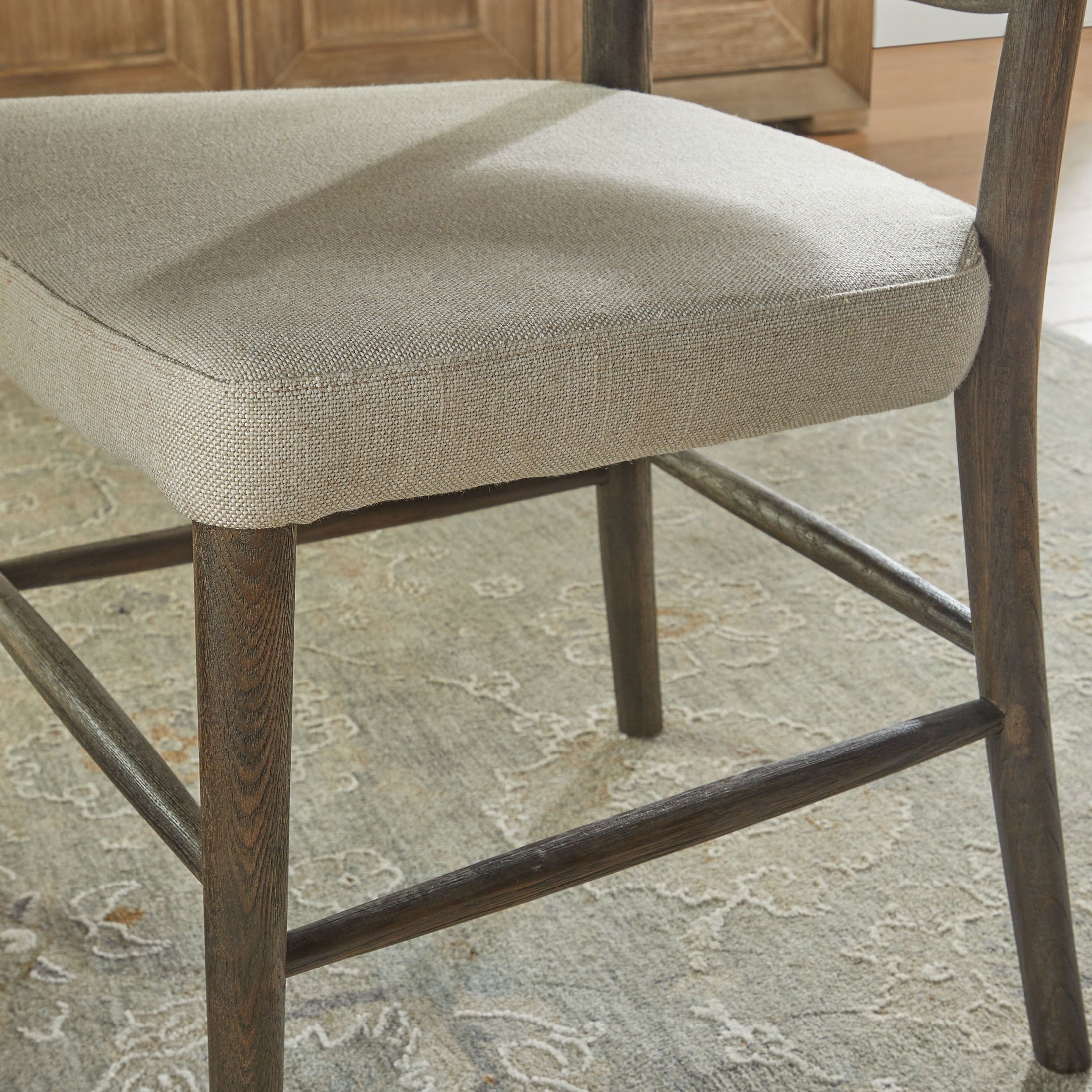 Close-up of Essentials for Living Cela Dining Chair with bisque upholstered seat and natural gray oak frame legs