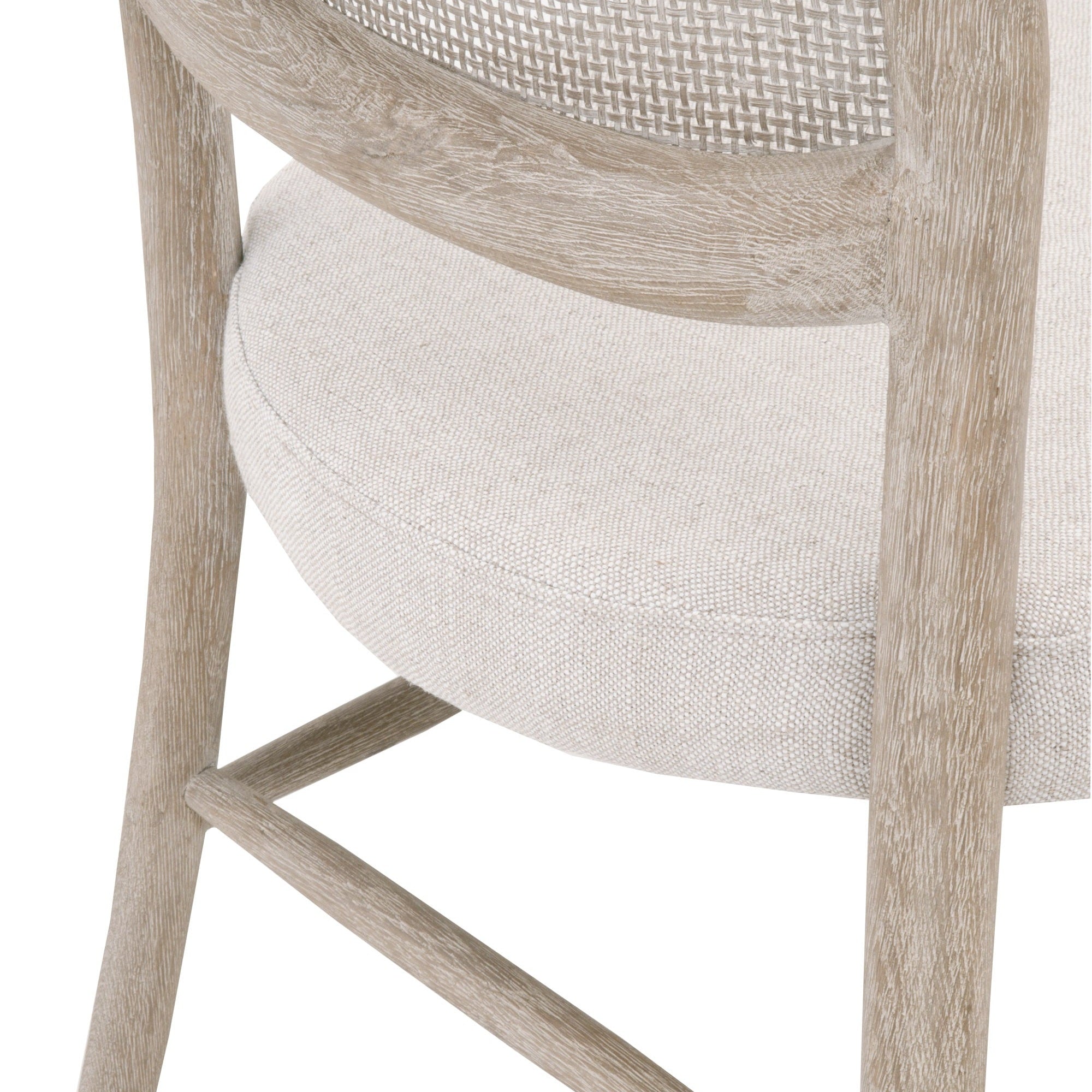 Close-up of Cela Dining Chair showing handwoven cane backrest and bisque upholstered seat with natural gray oak frame