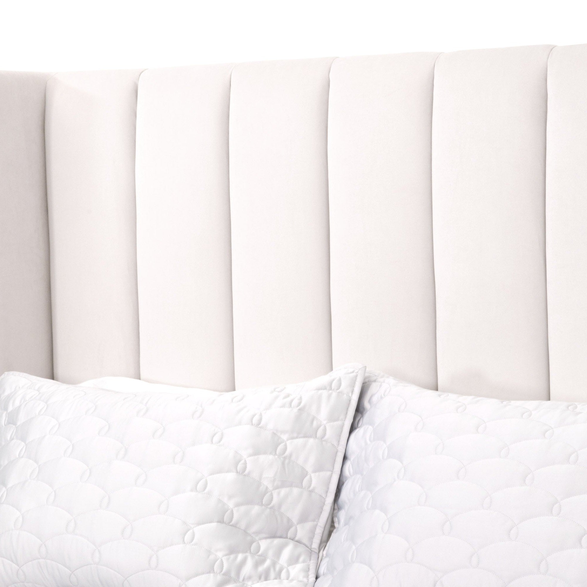 Close-up of Chandler Standard King Bed wingback headboard upholstered in cream velvet with vertical channel stitching.