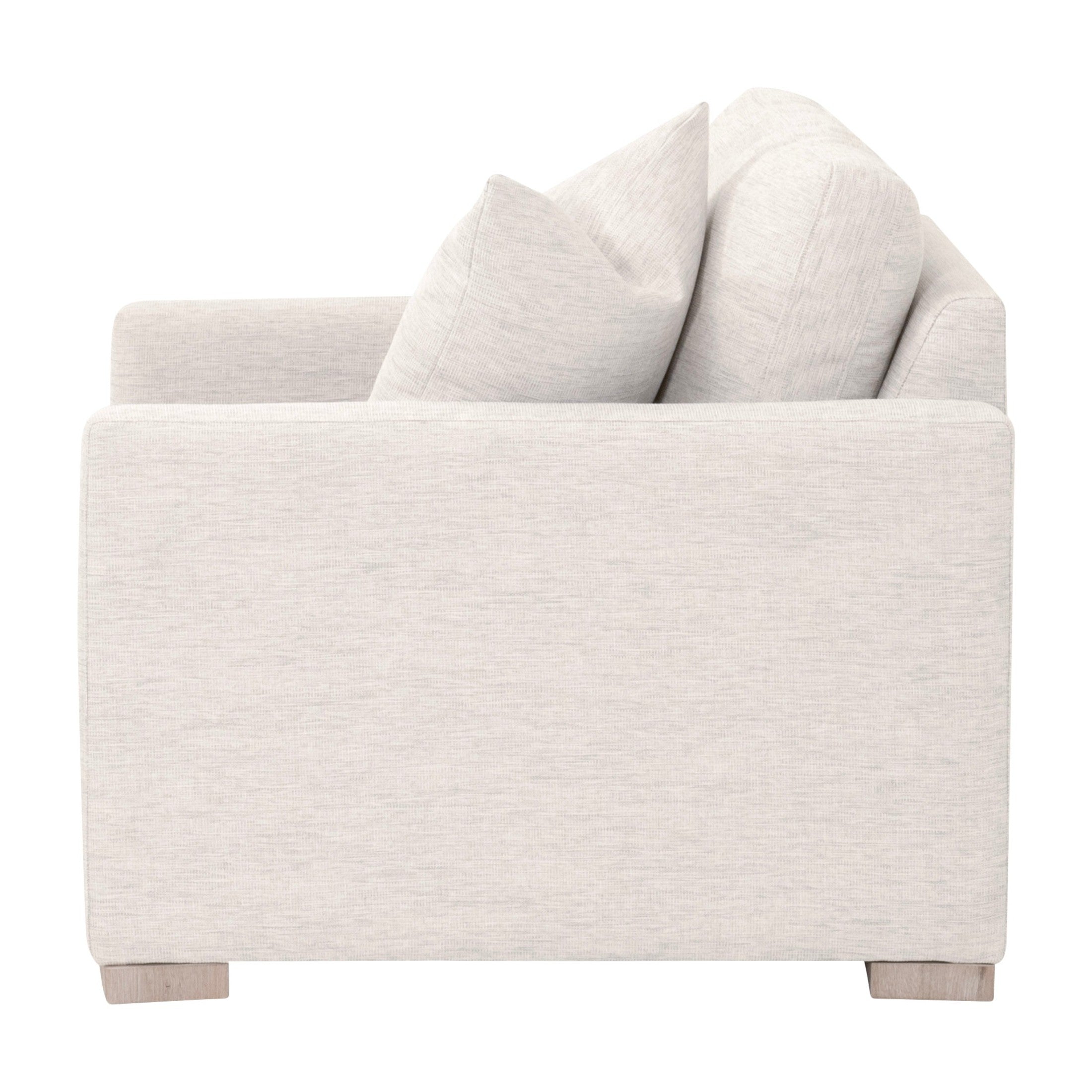 Side view of a Clara Slim Arm Sofa Chair in light gray performance fabric with plush cushions and wooden feet