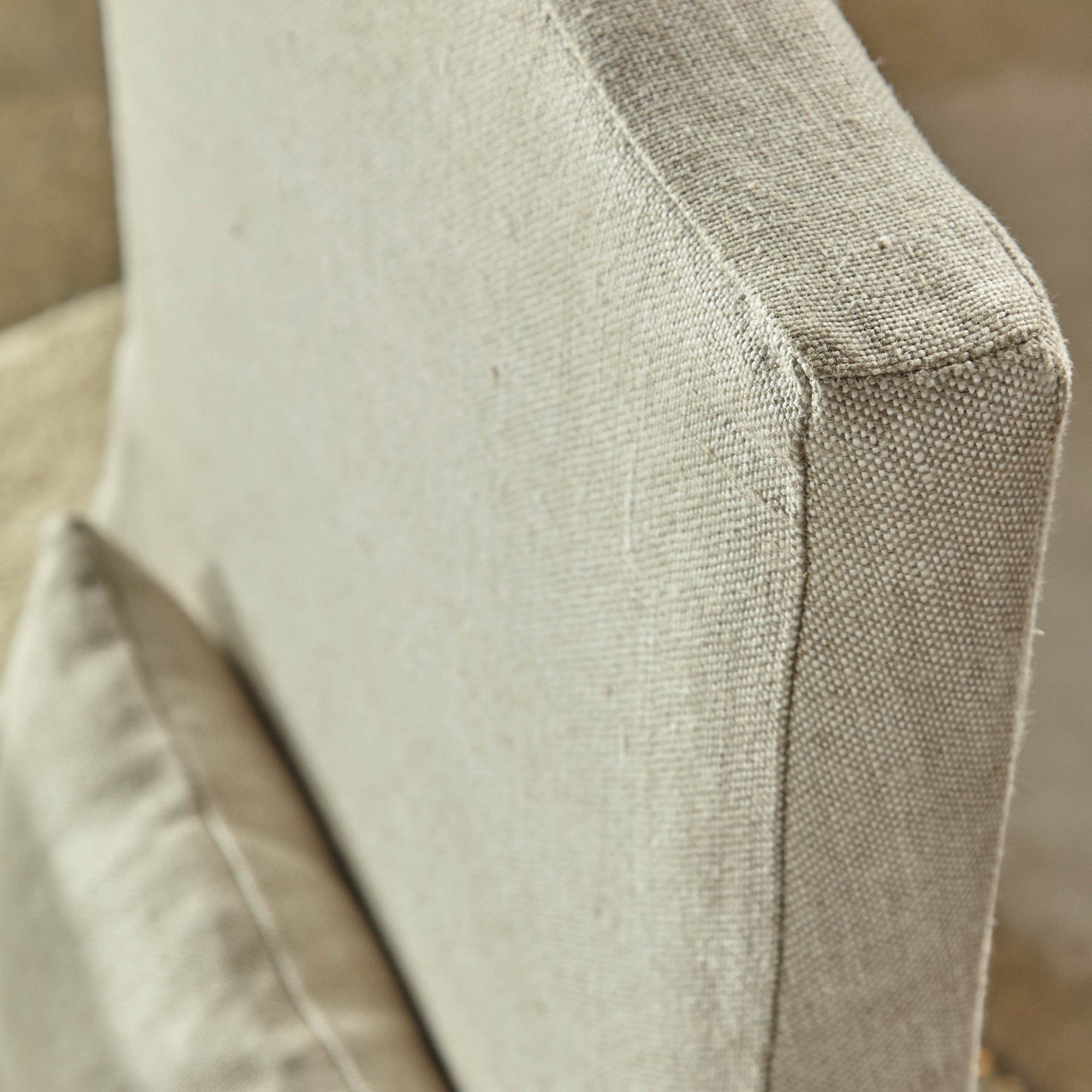Close-up view of creamy bisque French linen slipcover and soft lumbar pillow on Colette dining chair by Essentials for Living