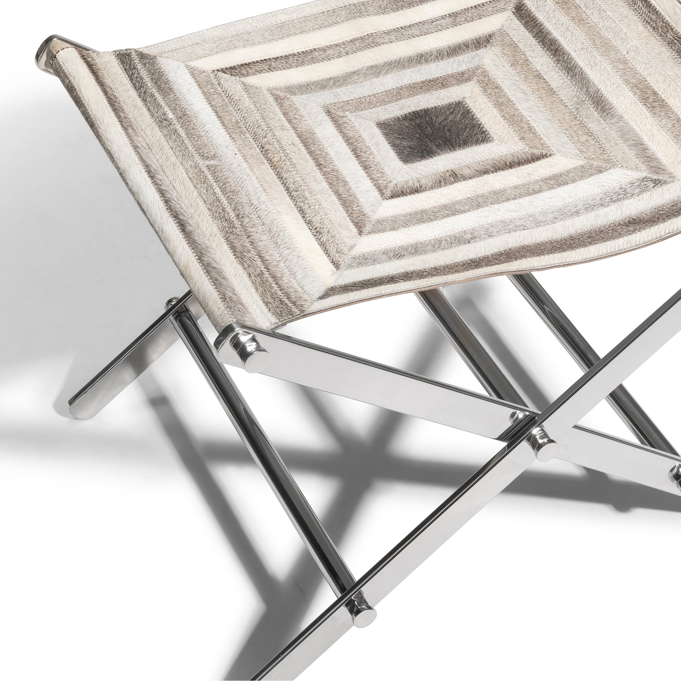 Close-up of GO HOME Ergo Cross Stool with grey hair-on-hide leather and polished nickel X-base folding frame.