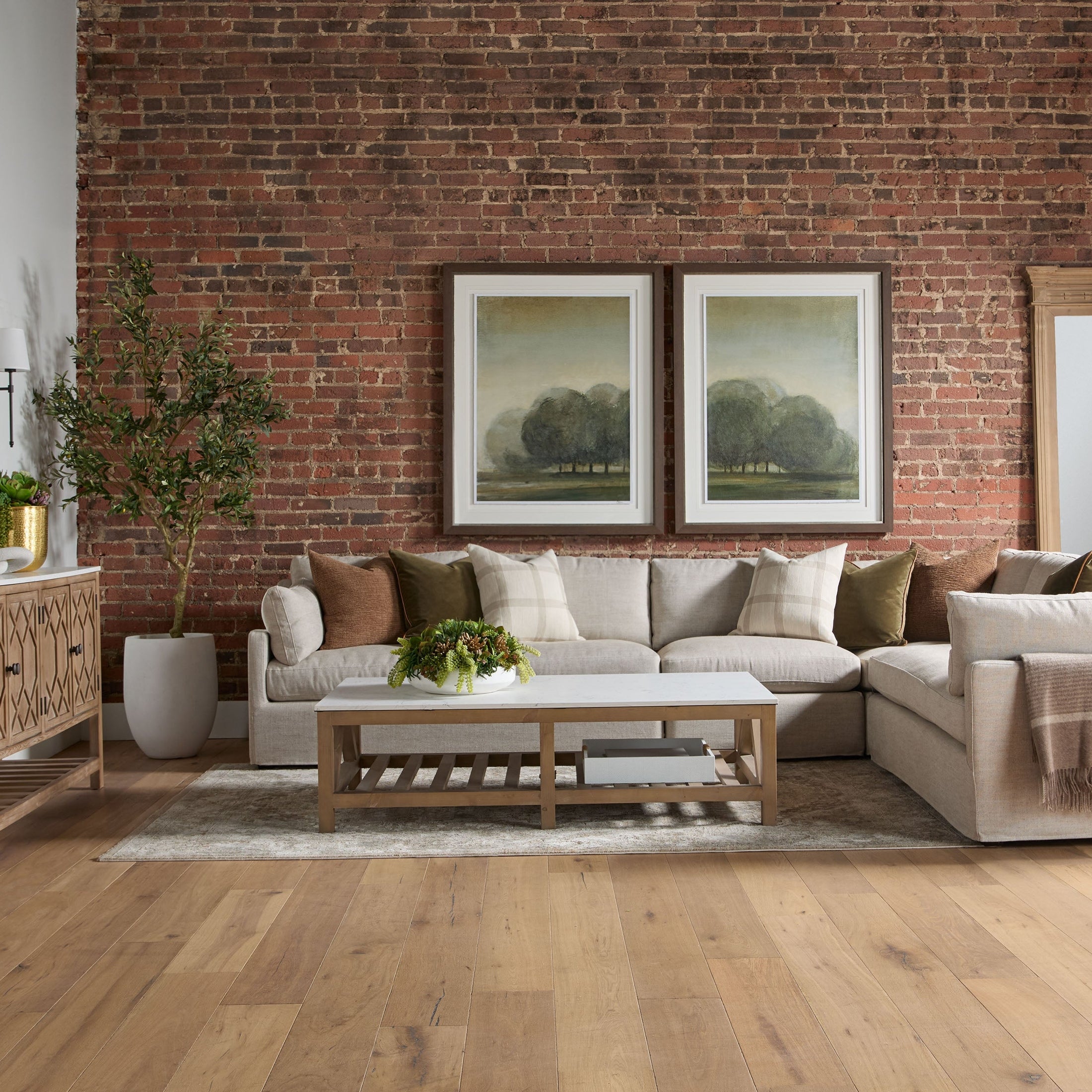 Cozy living room with sectional sofa and brick wall, styled for modern farmhouse decor by Essentials for Living Estate Mirror