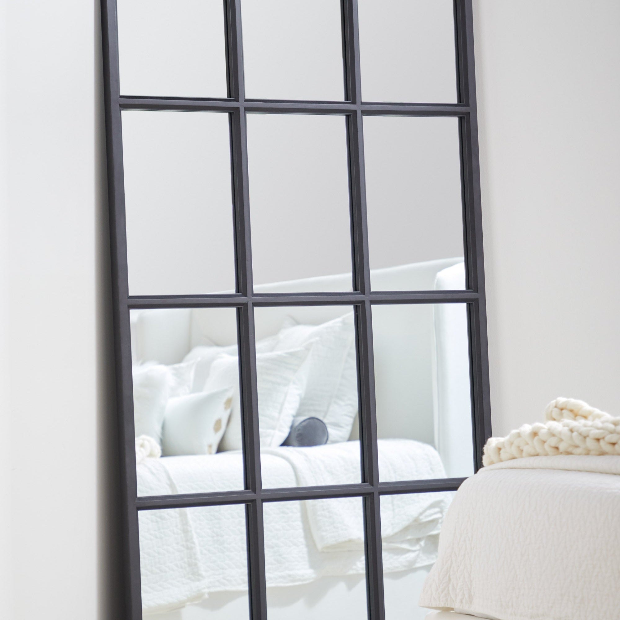 Grid Mirror with matte black oak frame and grid design leaning against wall in bedroom by Essentials for Living