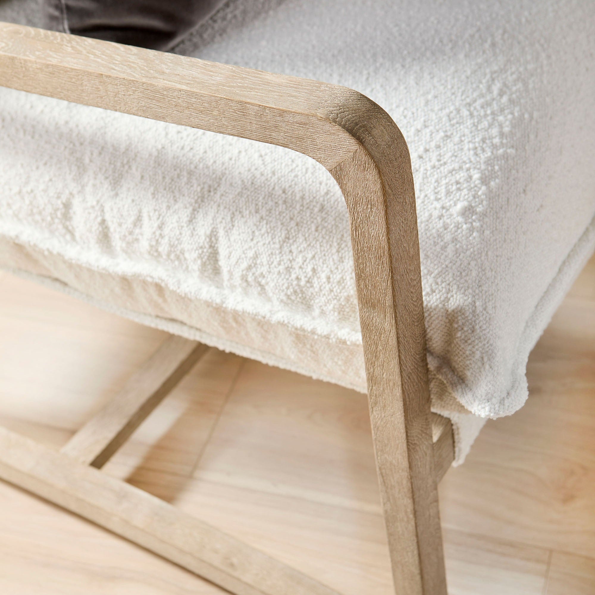 Close-up of Hamlin Club Chair’s natural gray oak sled base and soft white boucle fabric cushion by Essentials for Living
