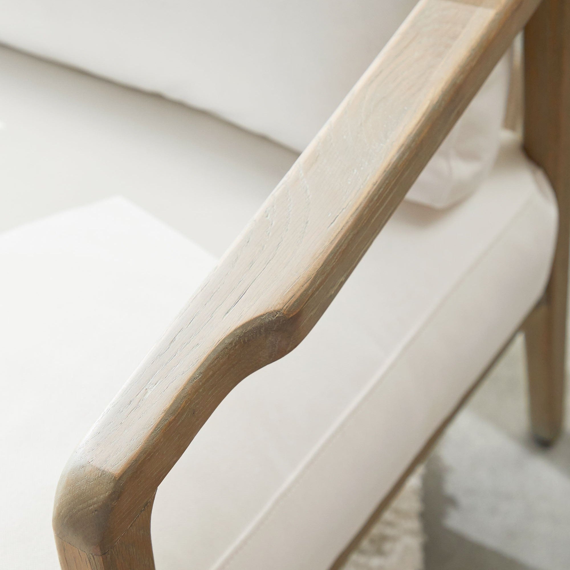 Close-up of Harbor Club Chair’s smoke-gray oak armrest with white upholstery by Essentials For Living