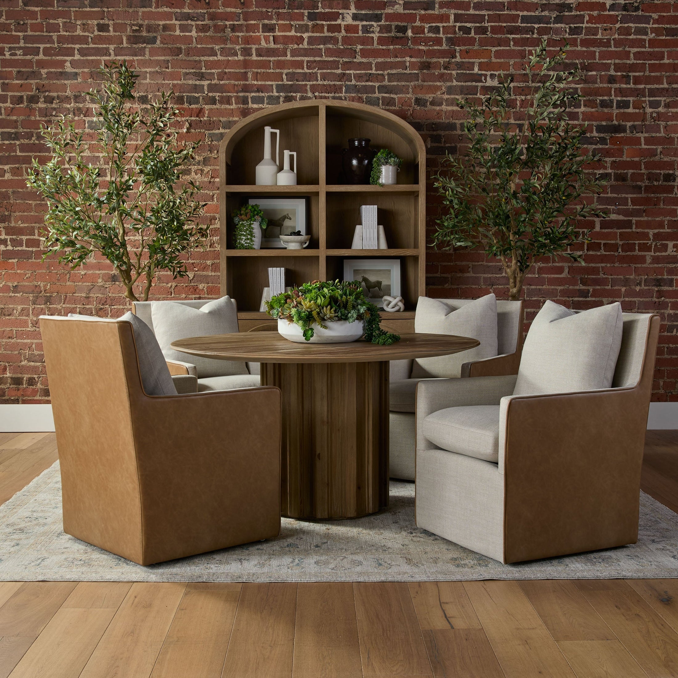 Essentials For Living Harmony Arm Chairs with two-tone upholstery and casters around a round wooden dining table in a cozy room