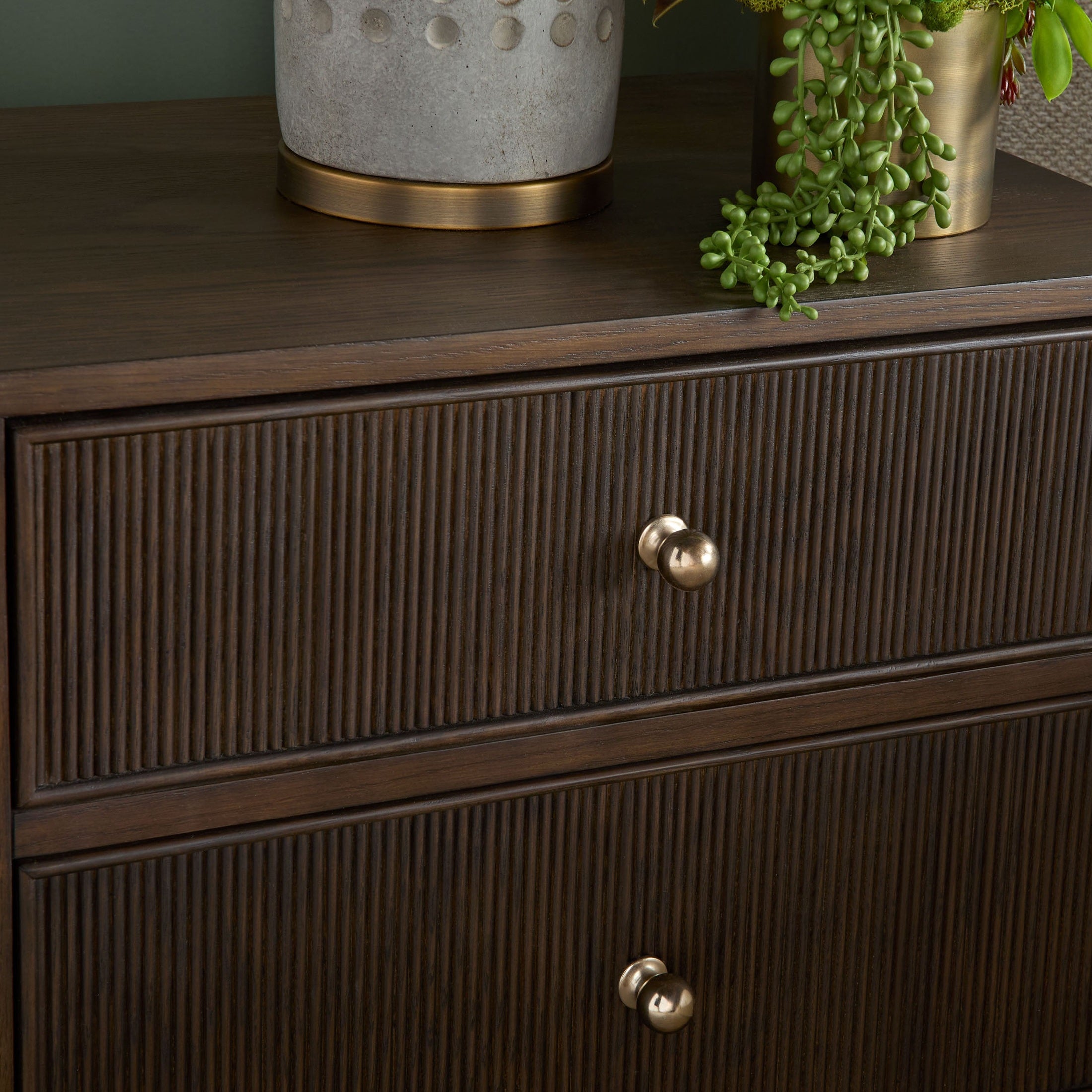 Close-up of dark wood Highland nightstand drawer front with fluted detailing and polished brass knob by Essentials for Living