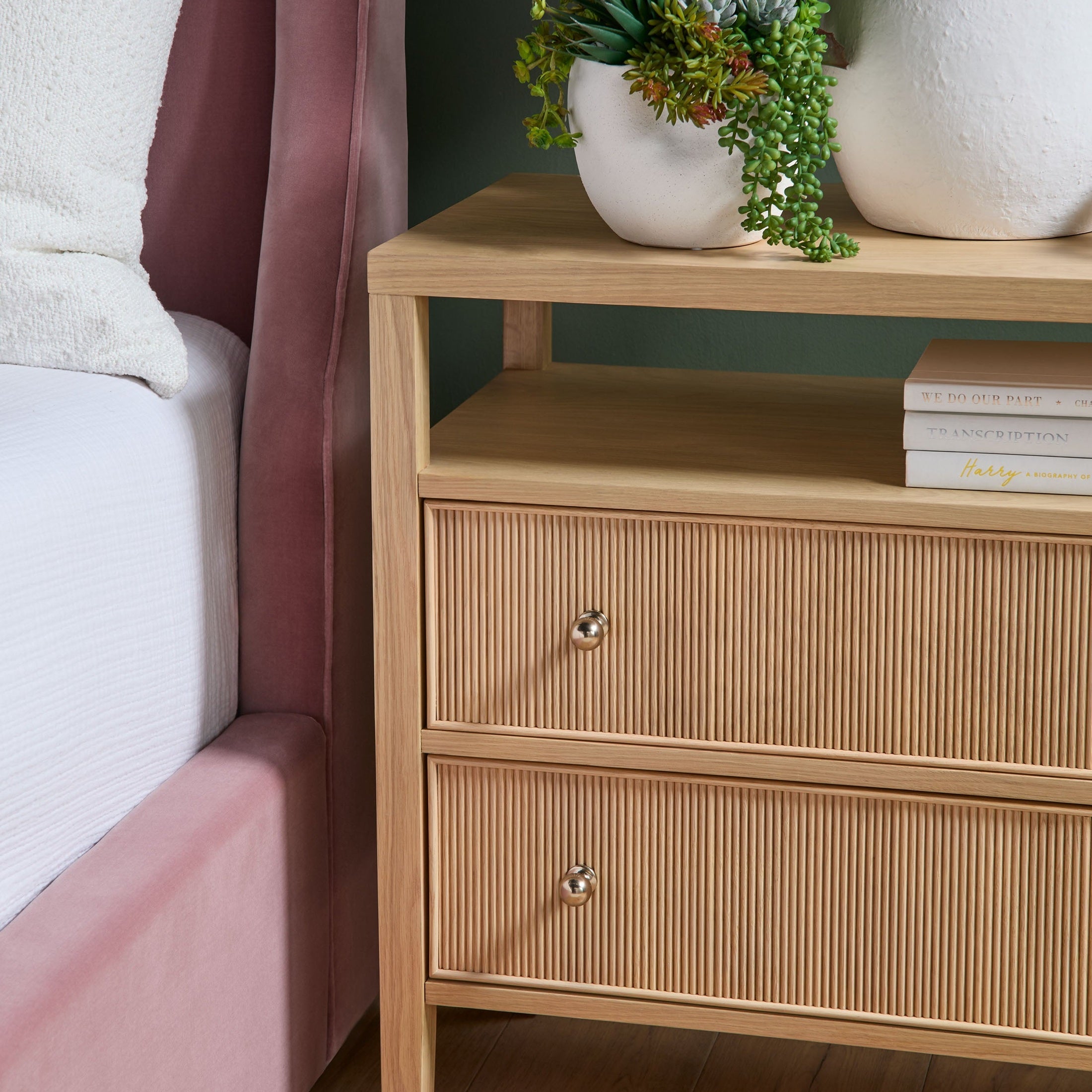 Essentials For Living Highland nightstand with two fluted front drawers and open shelf in natural oak finish beside bed