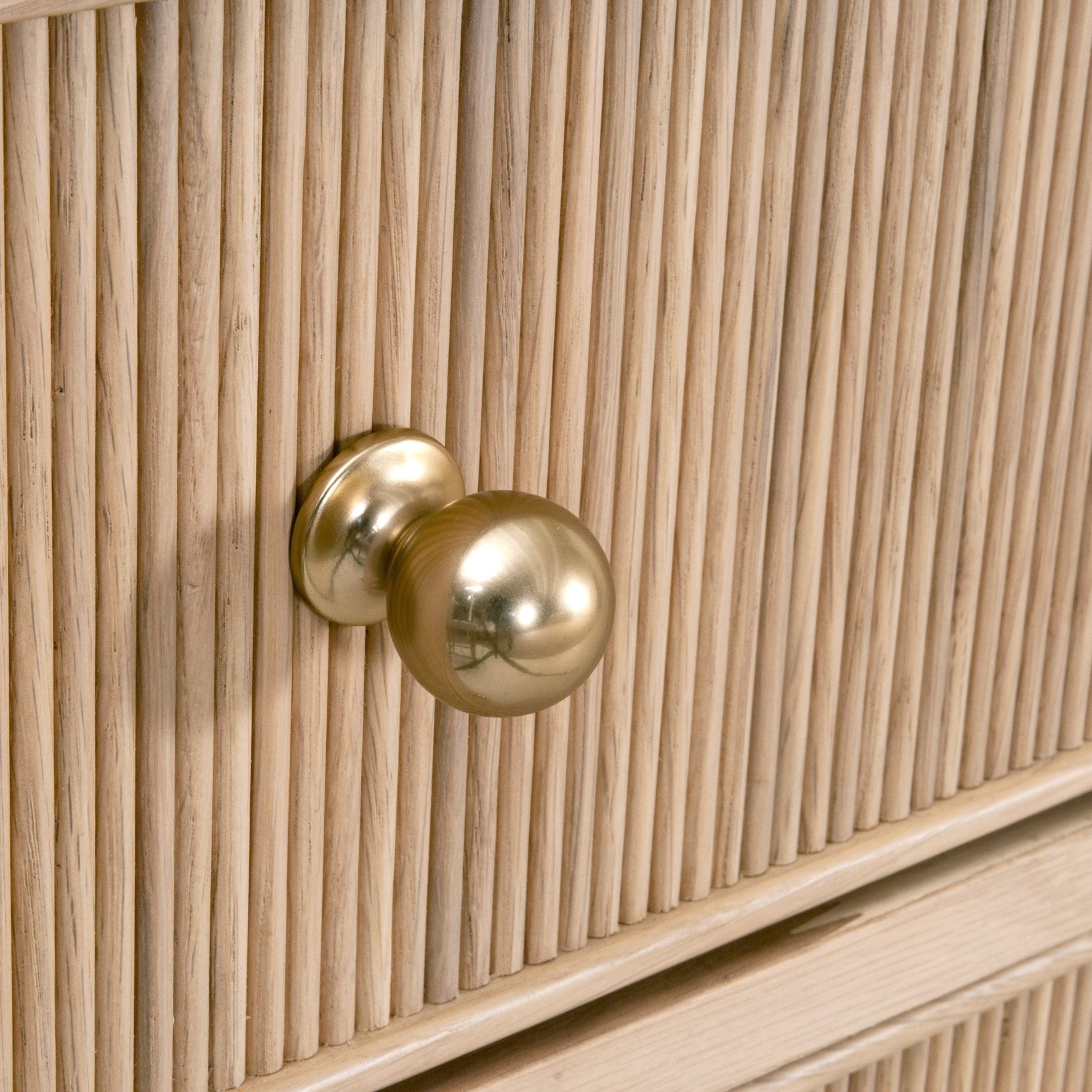 Polished brass knob on fluted natural oak drawer front of Essentials For Living Highland 8-Drawer Double Dresser