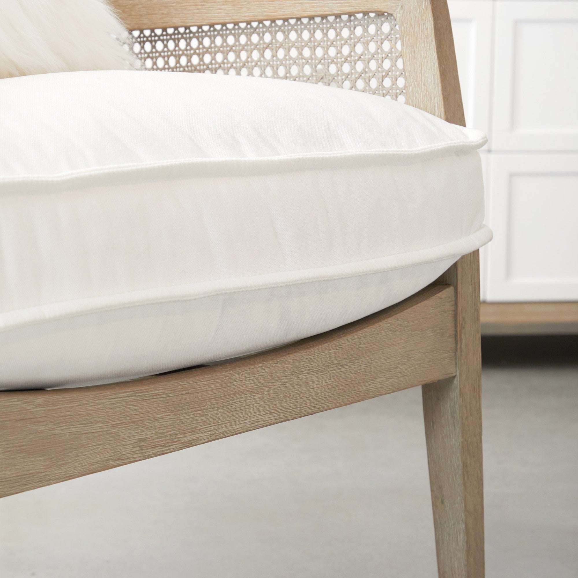 Close-up of Essentials for Living Leone Club Chair cushion and natural gray oak frame with handwoven cane details