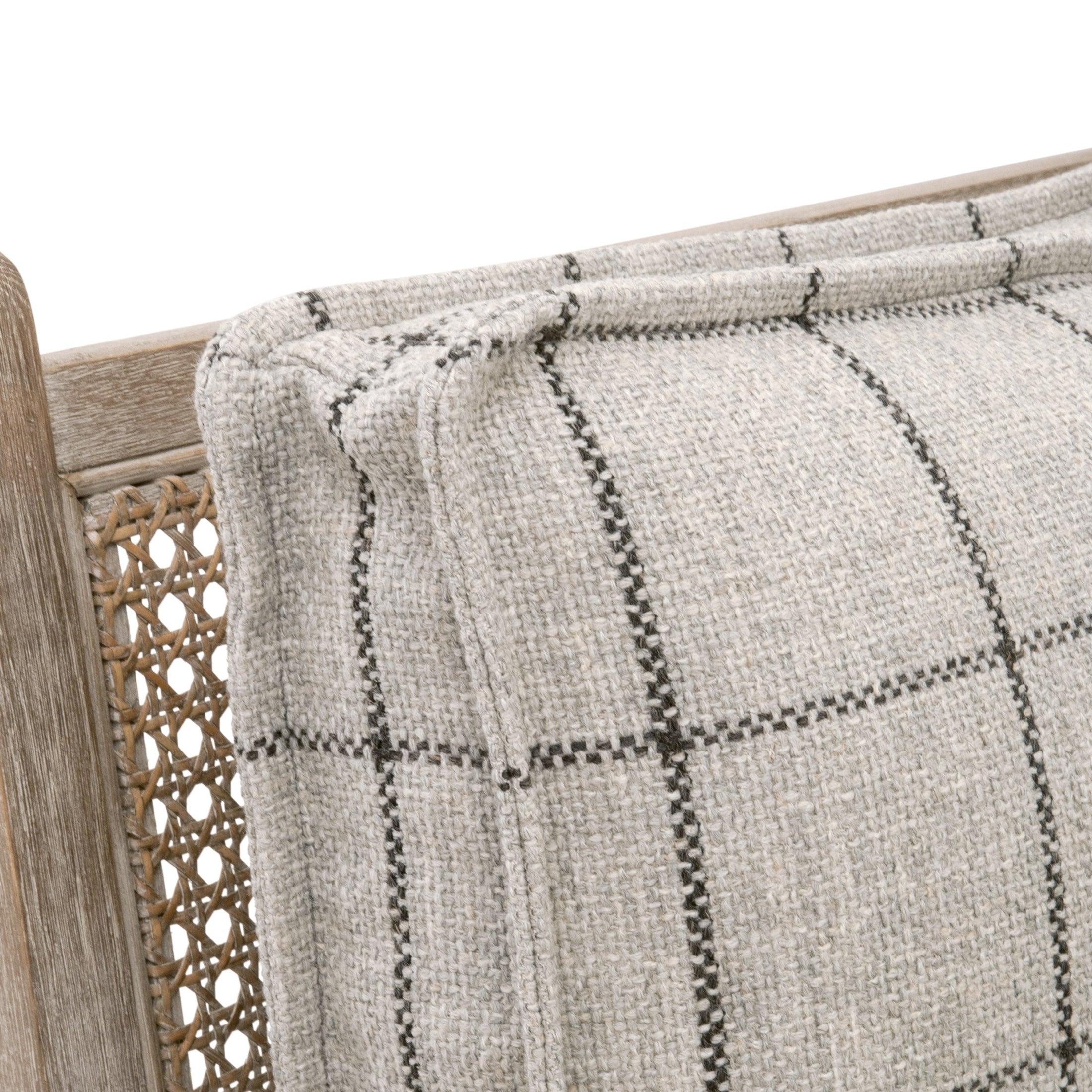 Close-up of textured windowpane plaid cushion on natural gray oak frame with handwoven cane back of club chair.