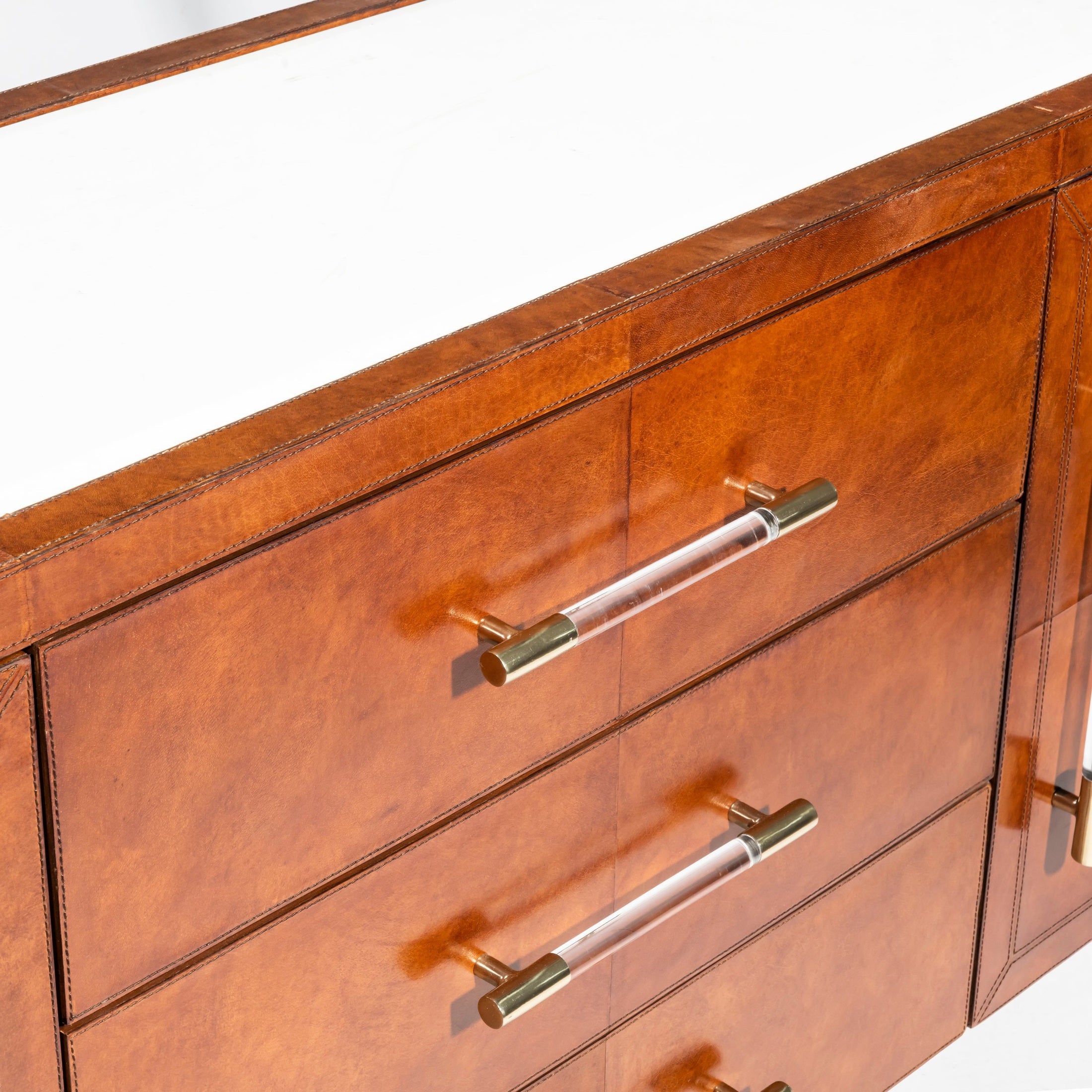 Close-up of Mason Sideboard with cognac leather, marble top, and lucite brass handles by GO HOME.