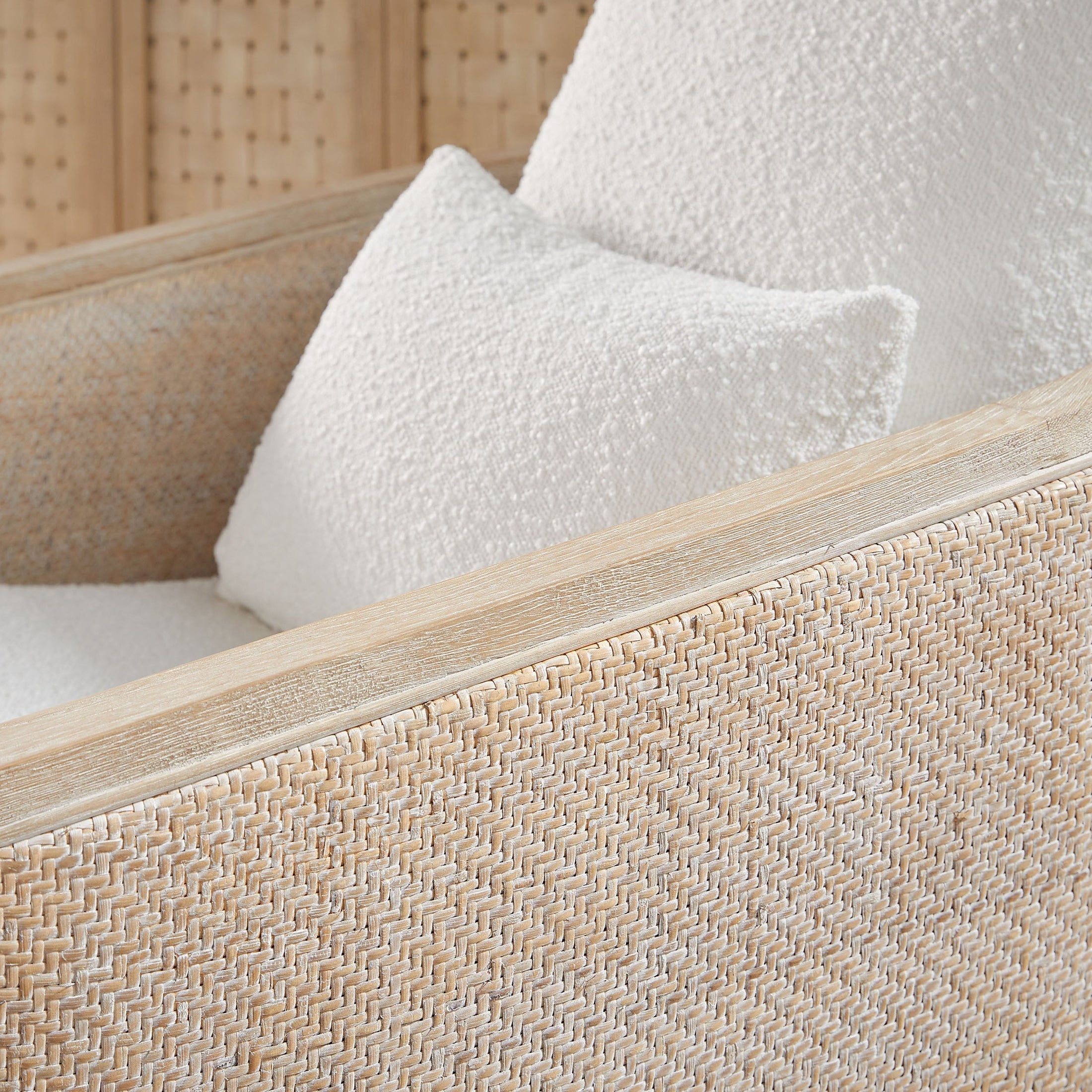 Close-up of Essentials For Living McGuire Swivel Club Chair with handwoven cane and white boucle cushions