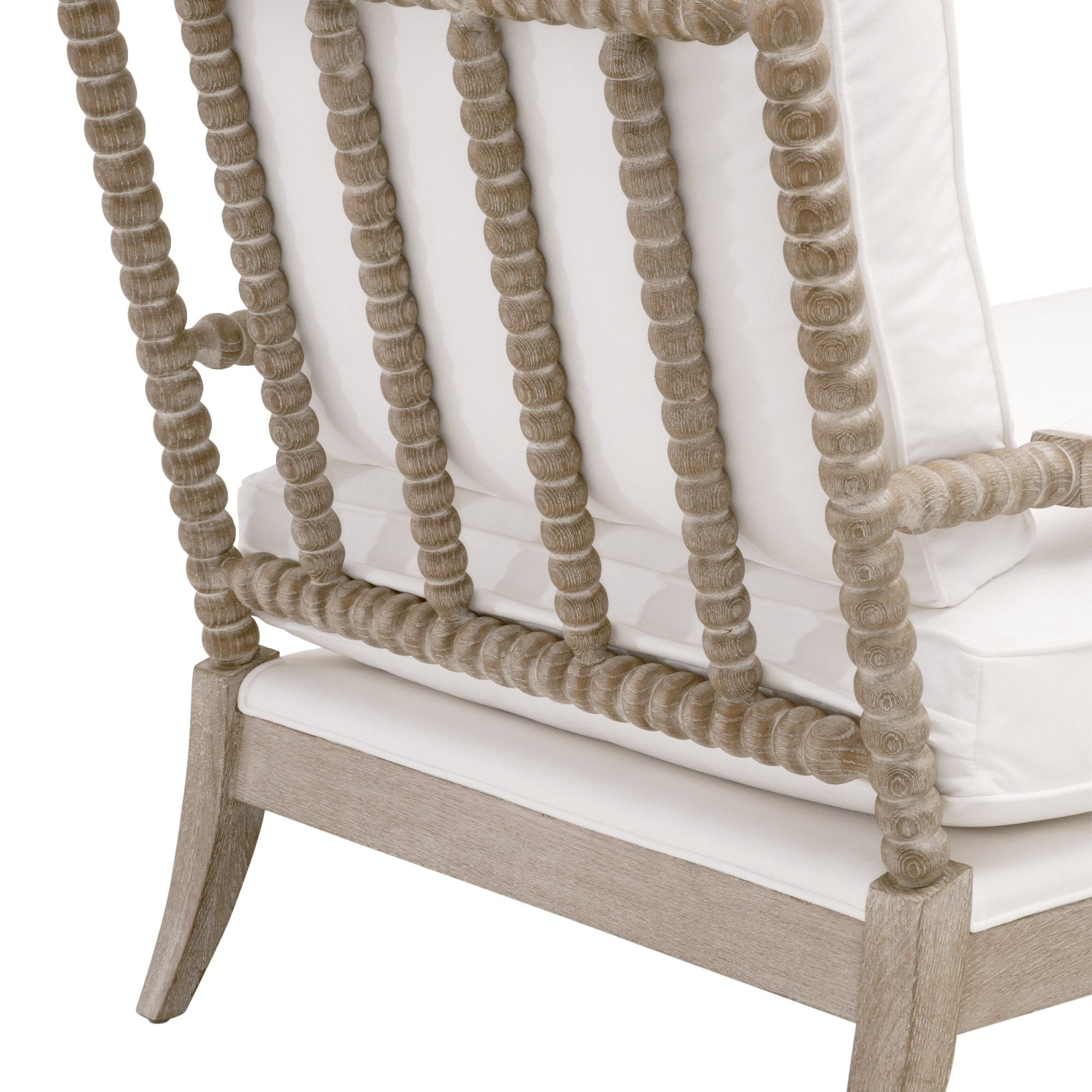 Close-up of Rouleau Chaise Lounge’s natural gray oak frame with carved spool-style detailing and white cushions