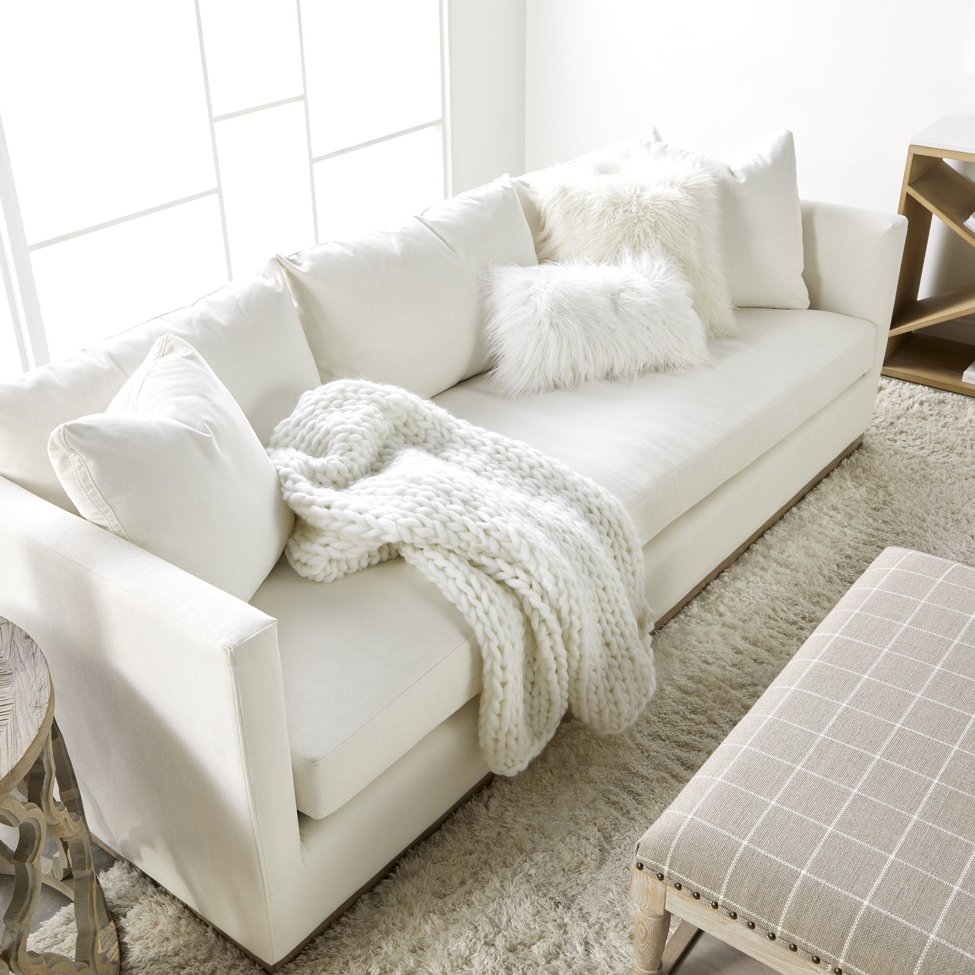 Ivory Siena 96" sofa by Essentials for Living with plush cushions and knit throw in bright, modern living room setting