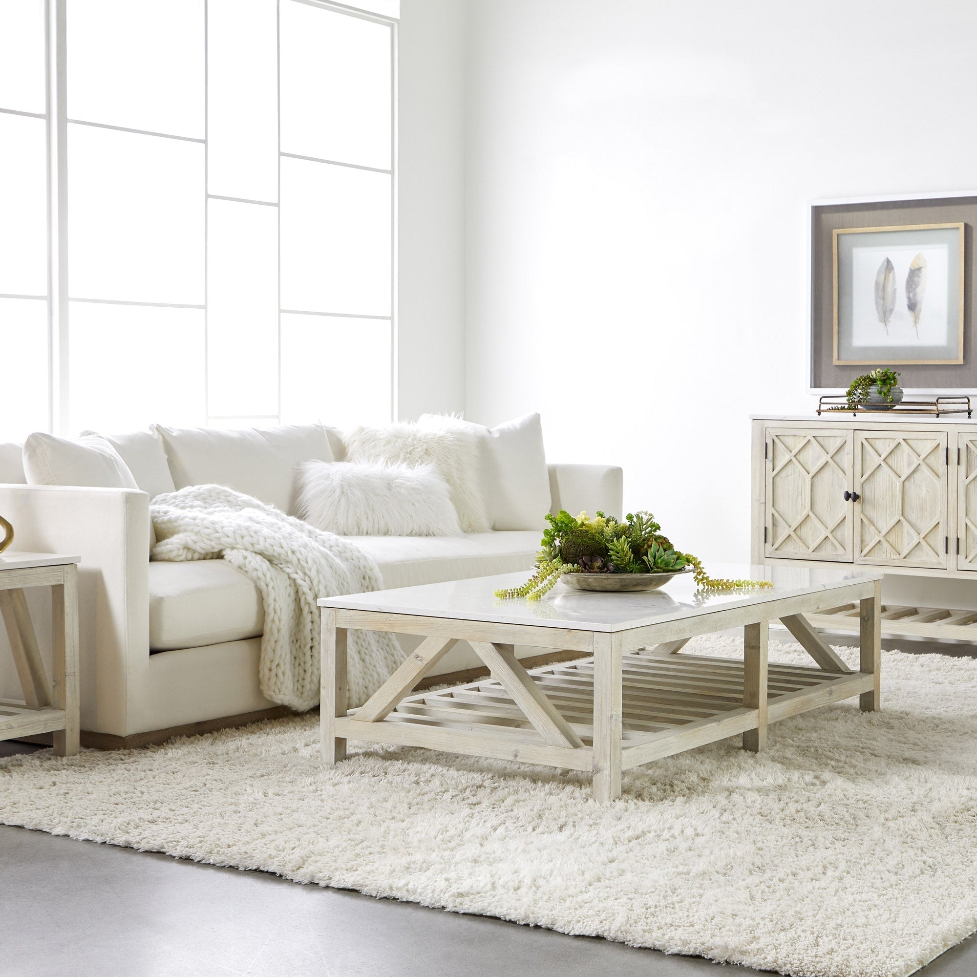 Essentials for Living Siena 96" ivory sofa with plush cushions and wood plinth base in a bright, modern living room setting