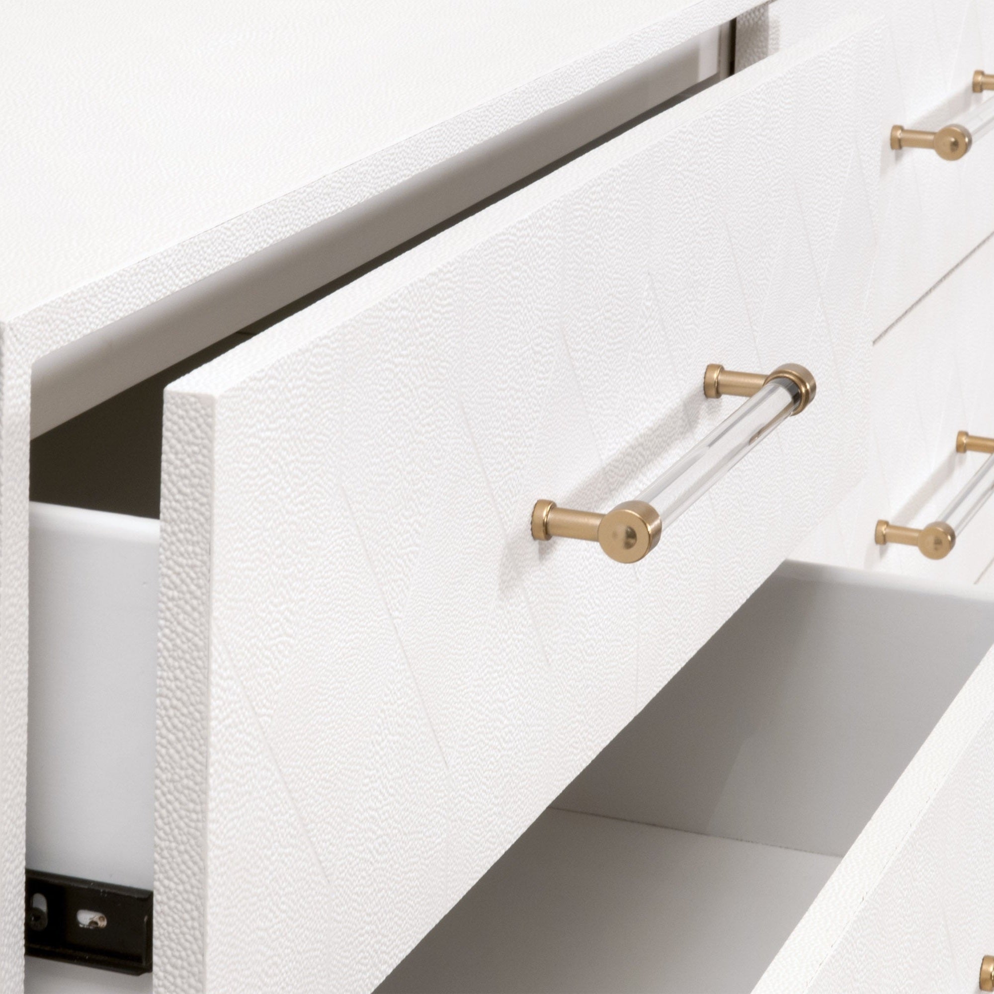 Close-up of the pearl-white faux shagreen drawer front with clear acrylic handle and brushed brass accents on dresser by Essentials for Living.