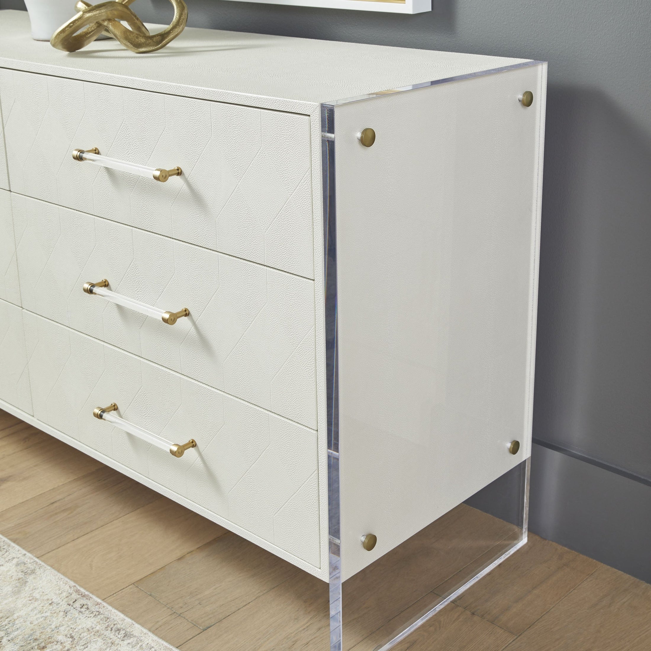 Pearl-white faux shagreen dresser with clear acrylic legs and brushed brass accents by Essentials For Living