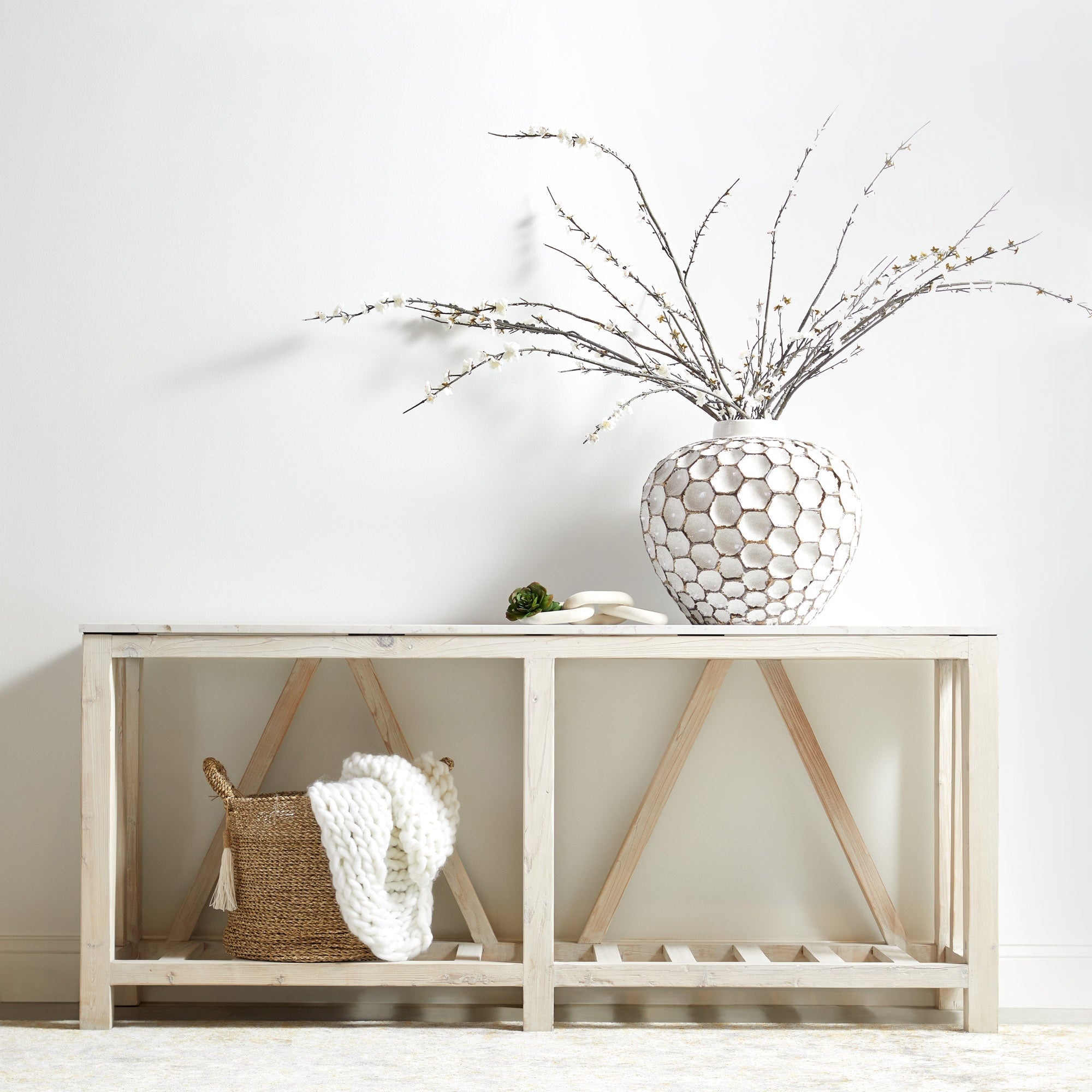 Essentials for Living Spruce Coffee Table in neutral tones with rustic wood trestle base and decorative vase on top