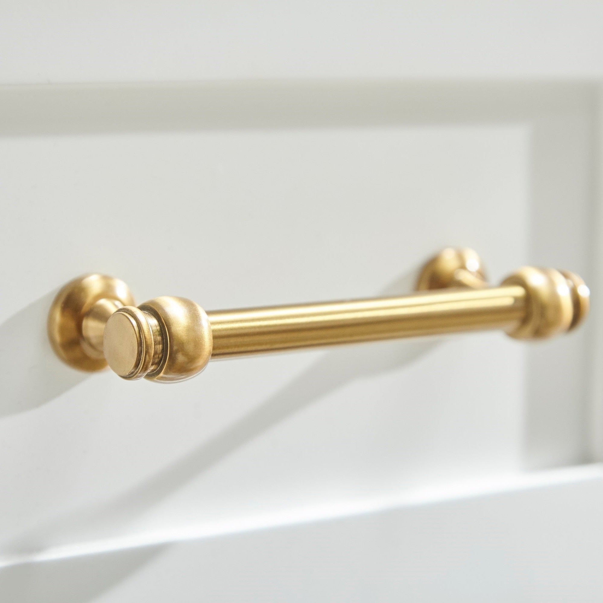 Close-up of brushed brass handle on white lacquer drawer of Stella 6-Drawer Double Dresser by Essentials for Living