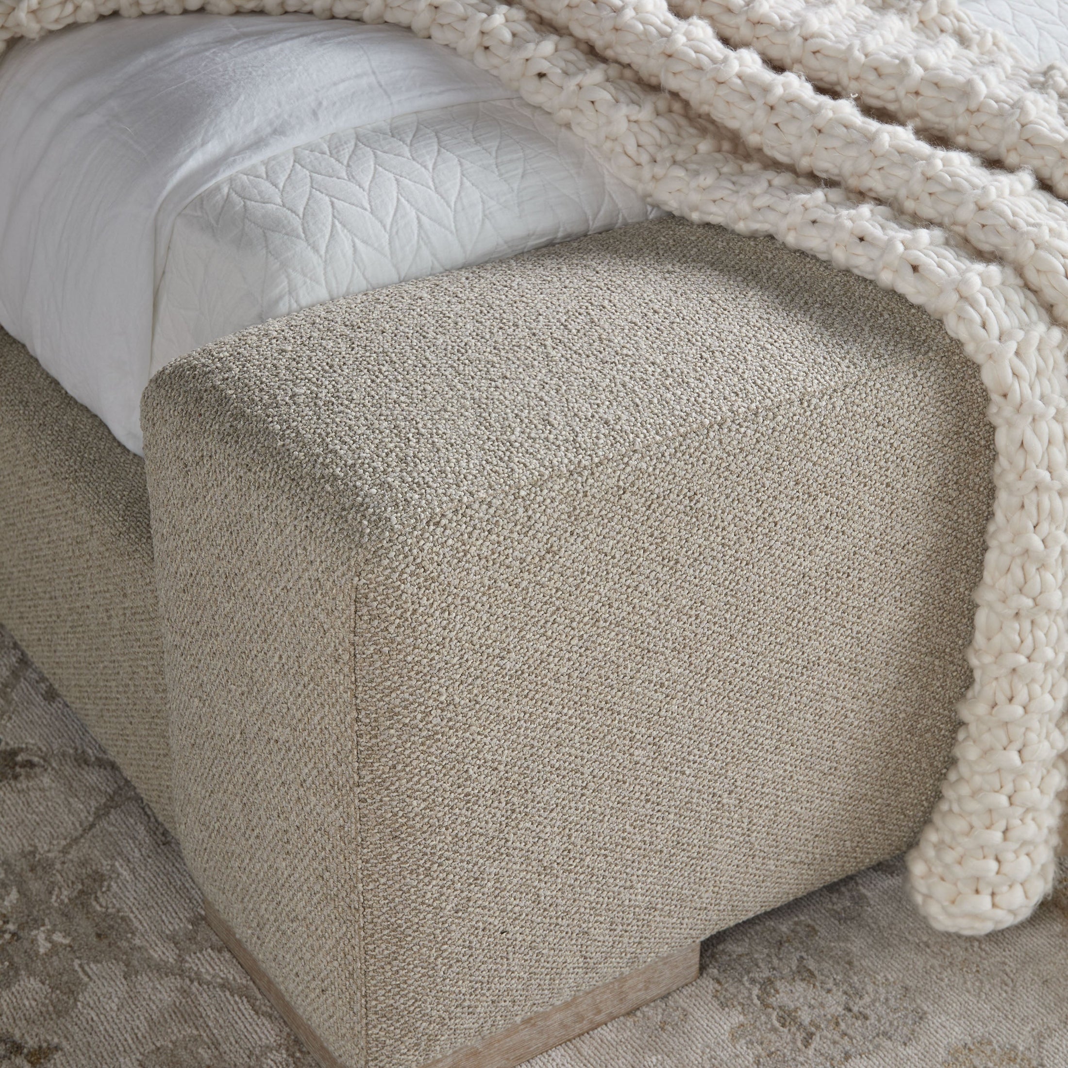 Close-up of upholstered footboard bench in textured boucle fabric on Essentials For Living Warren Queen Bed