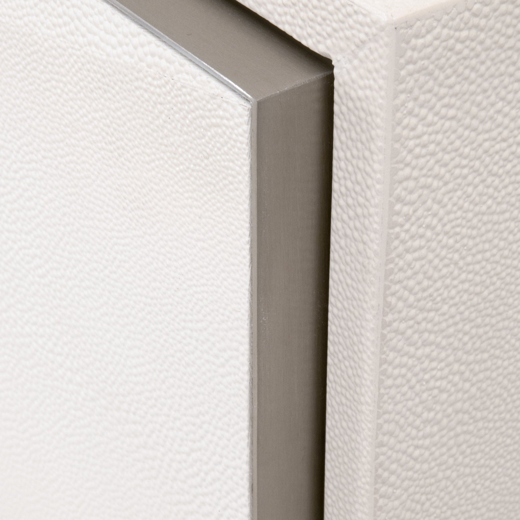 Close-up of pearl-white faux shagreen texture and brushed stainless-steel frame on Essentials For Living nightstand drawer edge