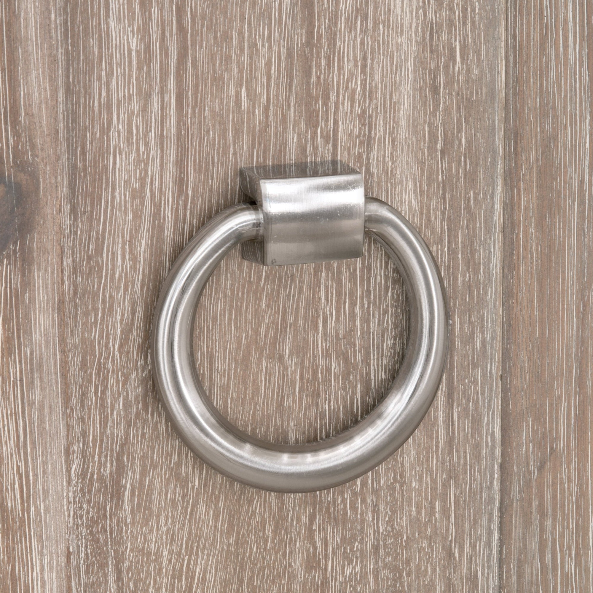 Close-up of brushed gold oversized ring pull on wood grain door of Azure Carrera Media Sideboard by Essentials for Living