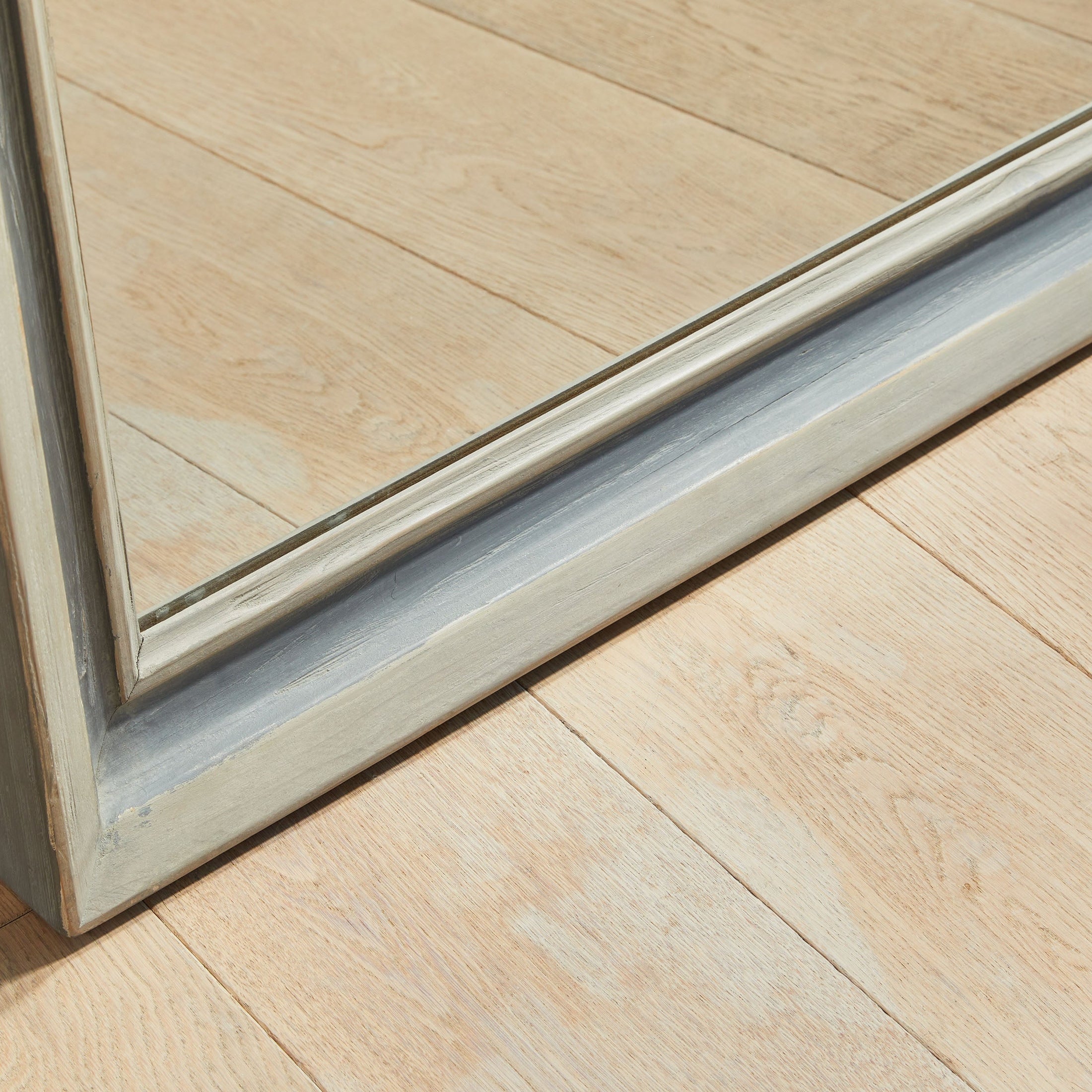 Close-up of the two-tone cream and gray reclaimed wood frame of the Caden Mirror by Essentials for Living