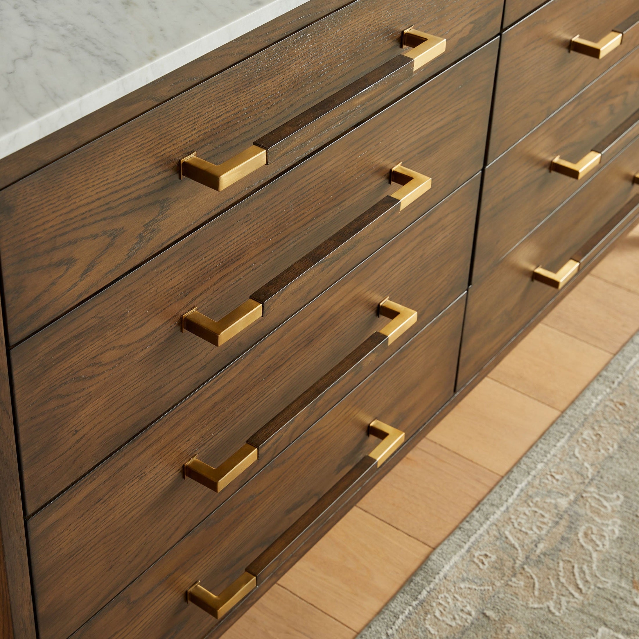Close-up of Cambria 8-Drawer Double Dresser with Dutch brown oak, marble top, and brass pulls by Essentials for Living