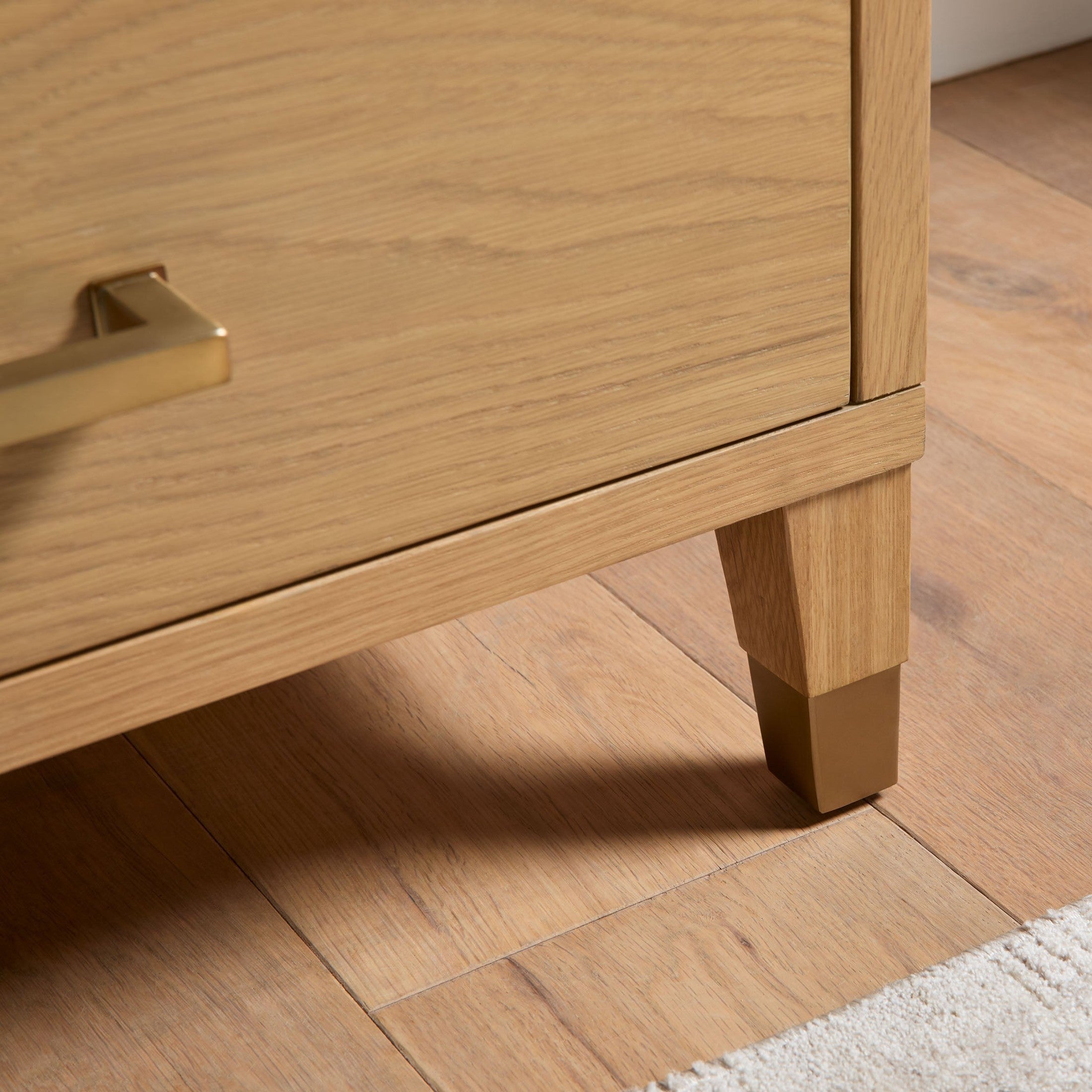 Close-up of aged brass drawer pull and matching feet on Cambria 8-Drawer Double Dresser by Essentials for Living