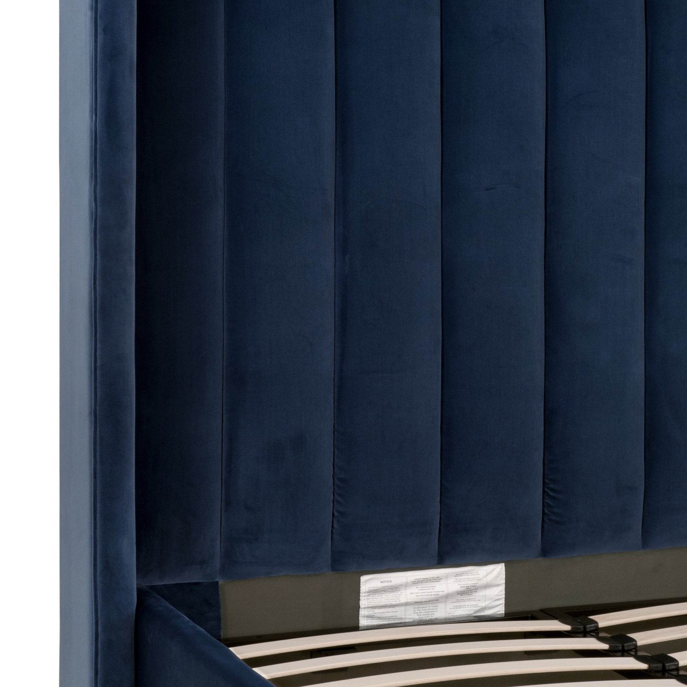 Close-up of navy blue velvet wingback headboard with vertical channel stitching on Chandler Queen Bed by Essentials for Living