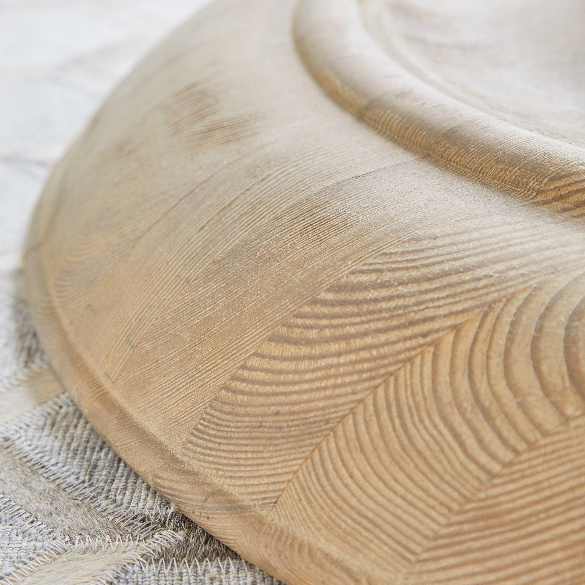 Close-up of the carved, reclaimed white pine pedestal base of the Chelsea 36" Round Dining Table by Essentials For Living