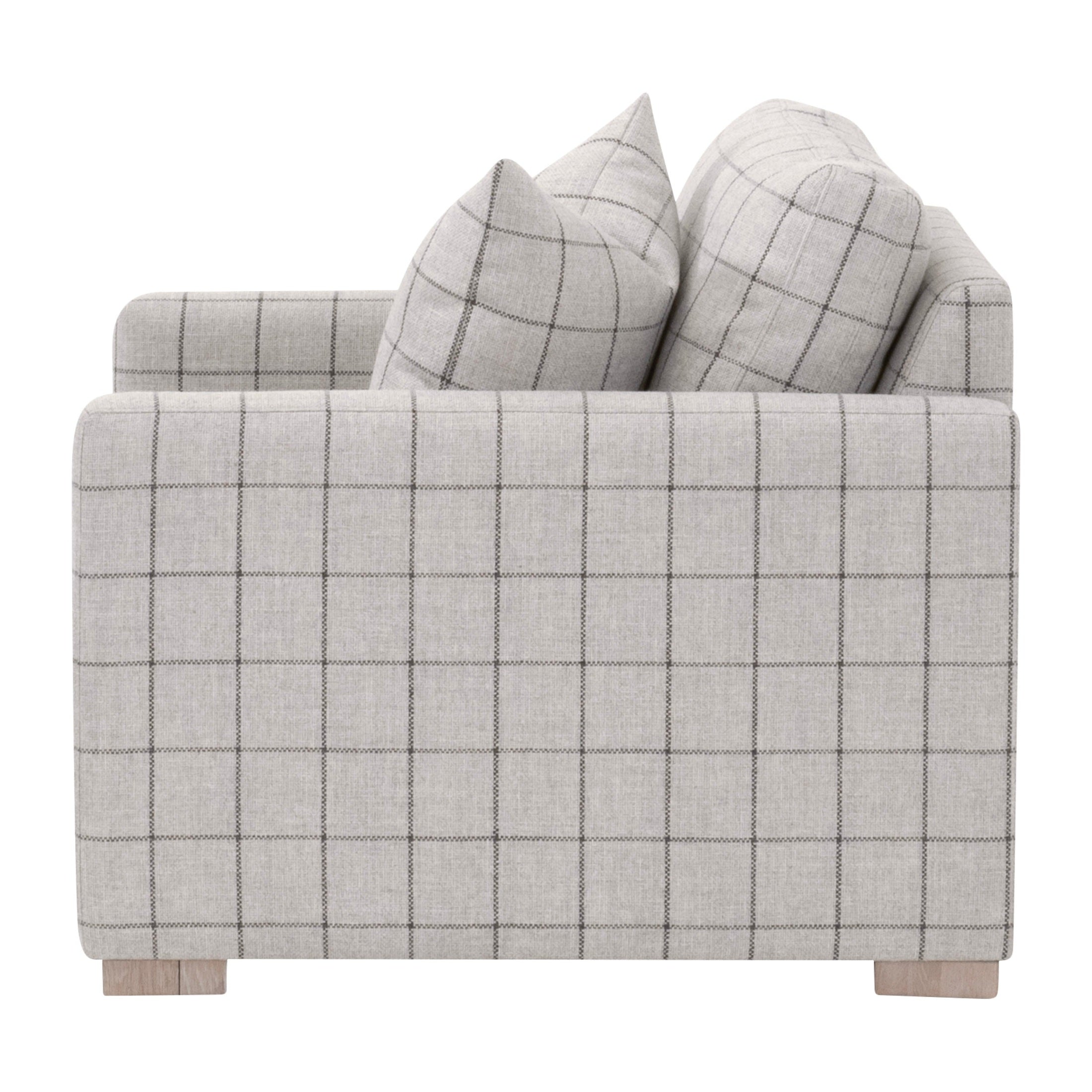 Side view of a light gray checkered Clara Slim Arm Sofa Chair with plush cushions and oak wood feet