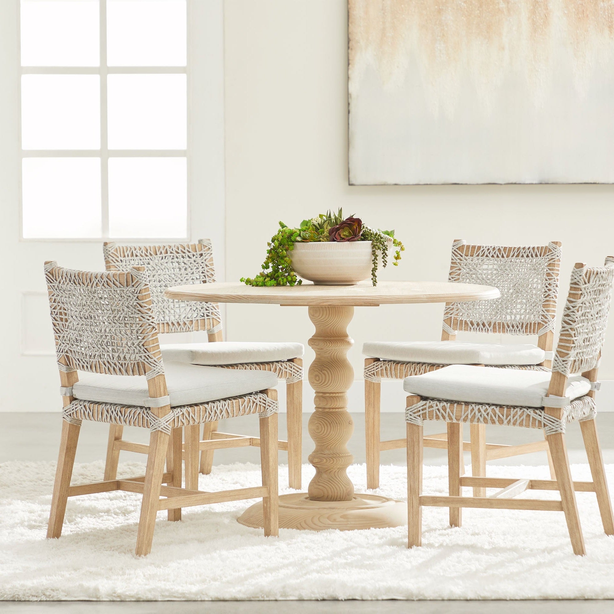 Set of two Essentials for Living Costa dining chairs with white taupe woven seats and solid wood legs around round table