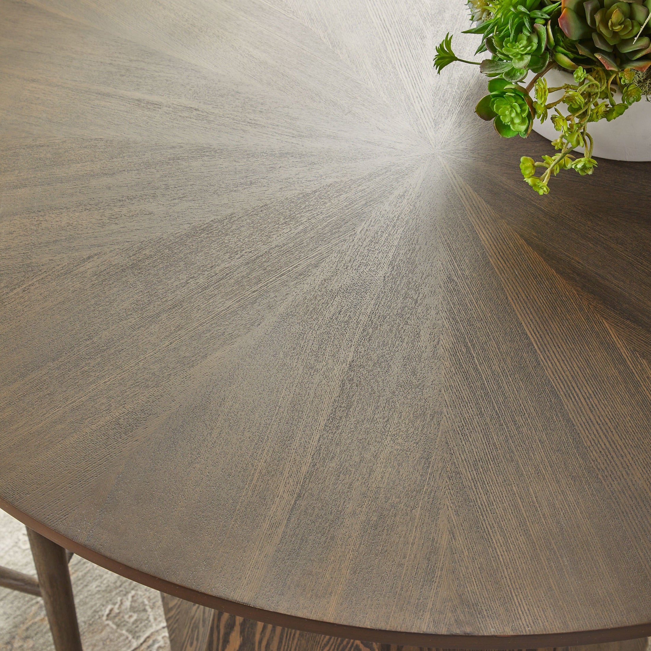 Close-up of Essentials for Living Coulter 42" round dining table top with starburst pattern and natural gray ash wood finish