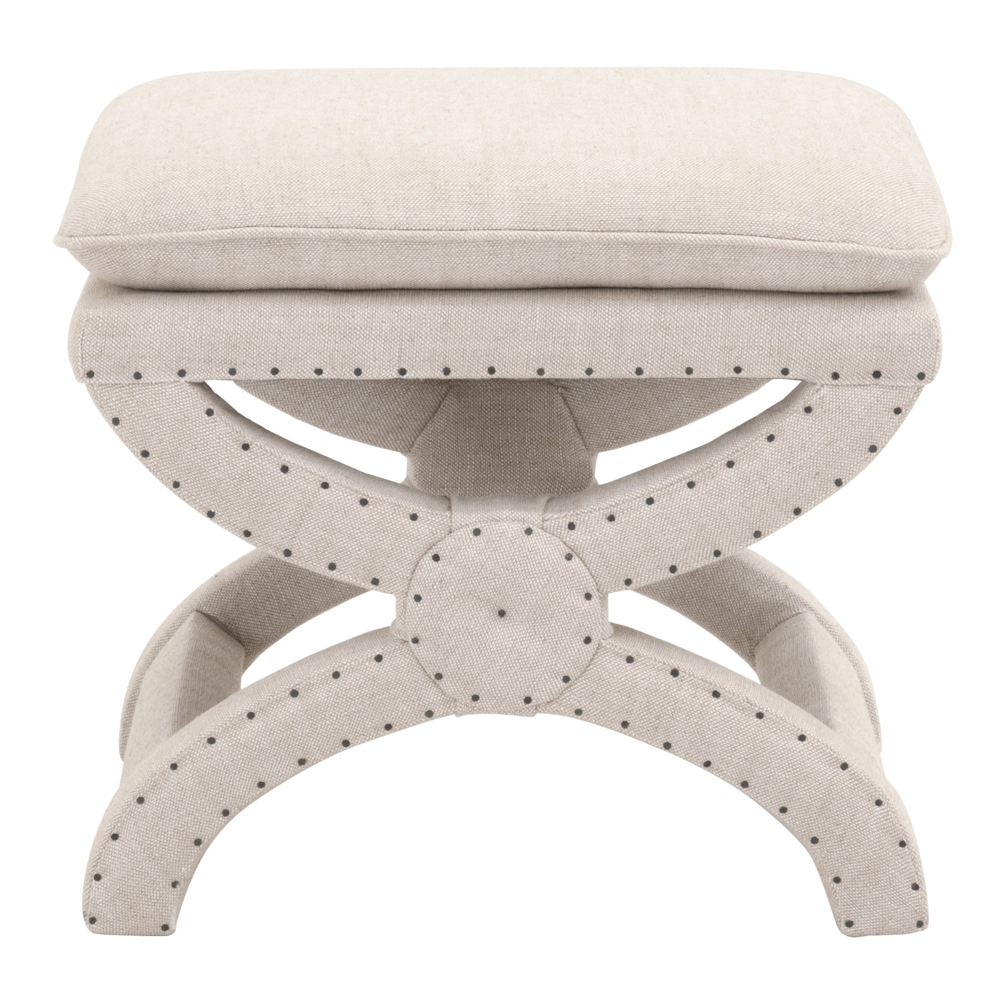 Creamy beige upholstered Gaston Ottoman with X-shaped base and black nailhead trim by Essentials for Living