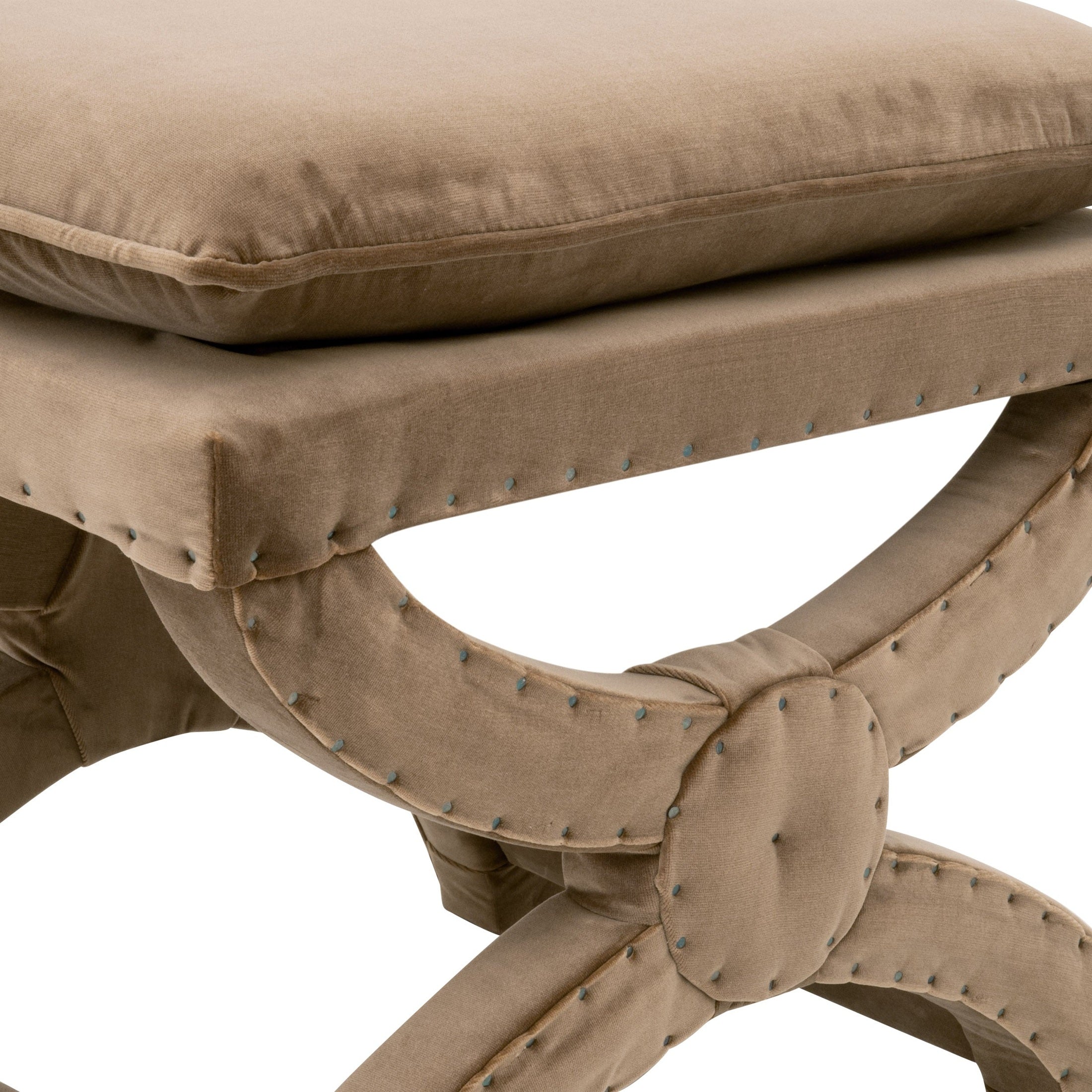 Close-up of creamy beige upholstered Gaston Ottoman with black nailhead trim and X-shaped base design by Essentials For Living