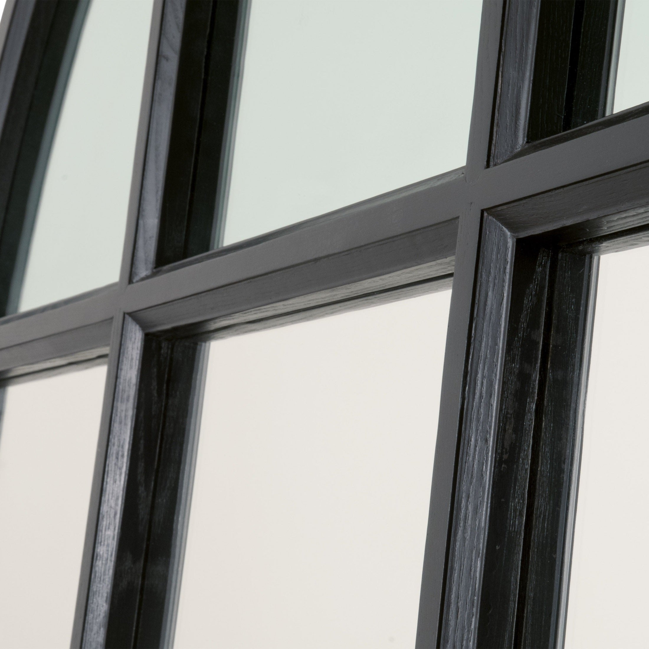 Close-up of Grid Arched Mirror's dark wood grid frame showcasing craftsmanship and clean reflective glass panels